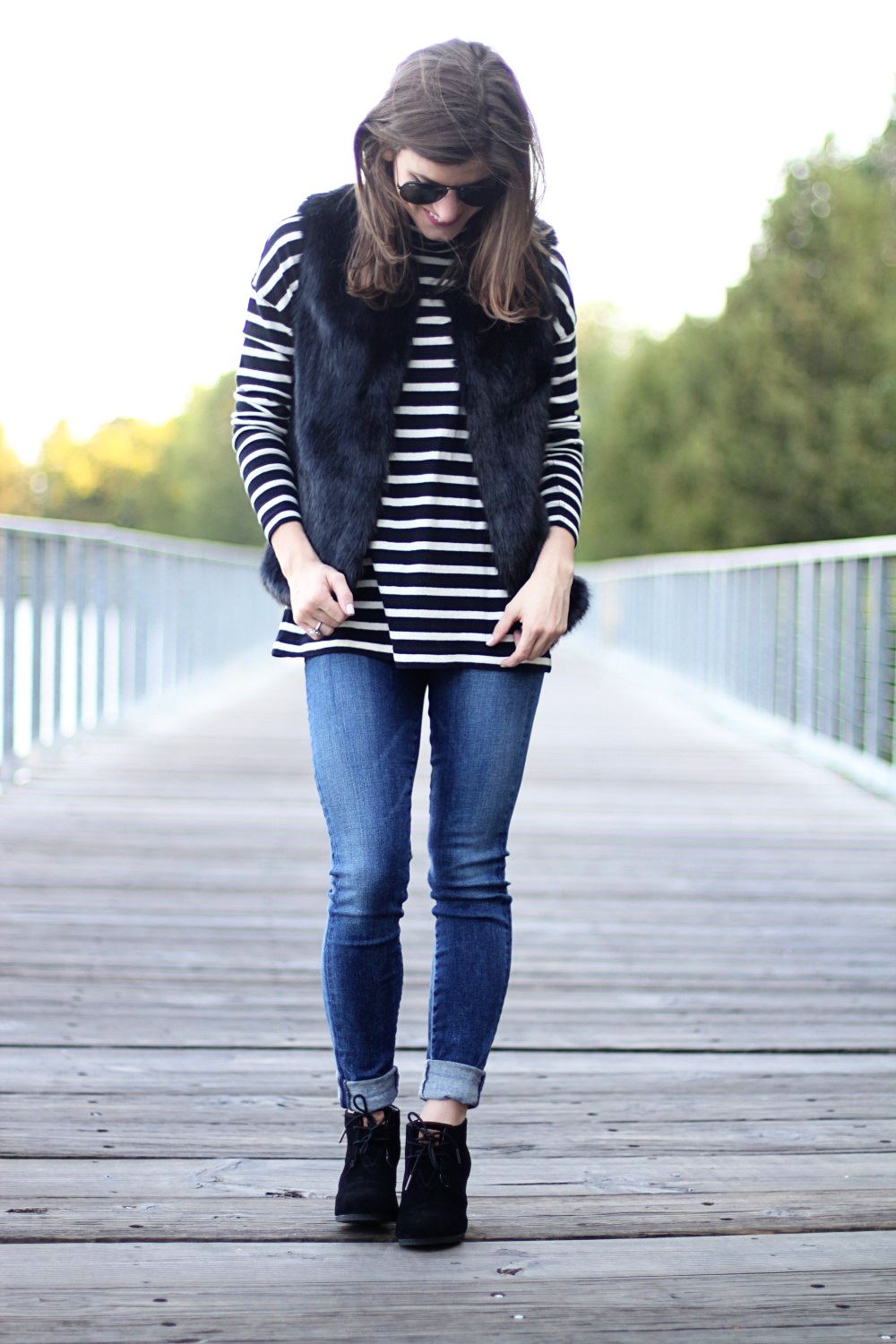 black faux fur vest and black and white striped turtleneck outfit