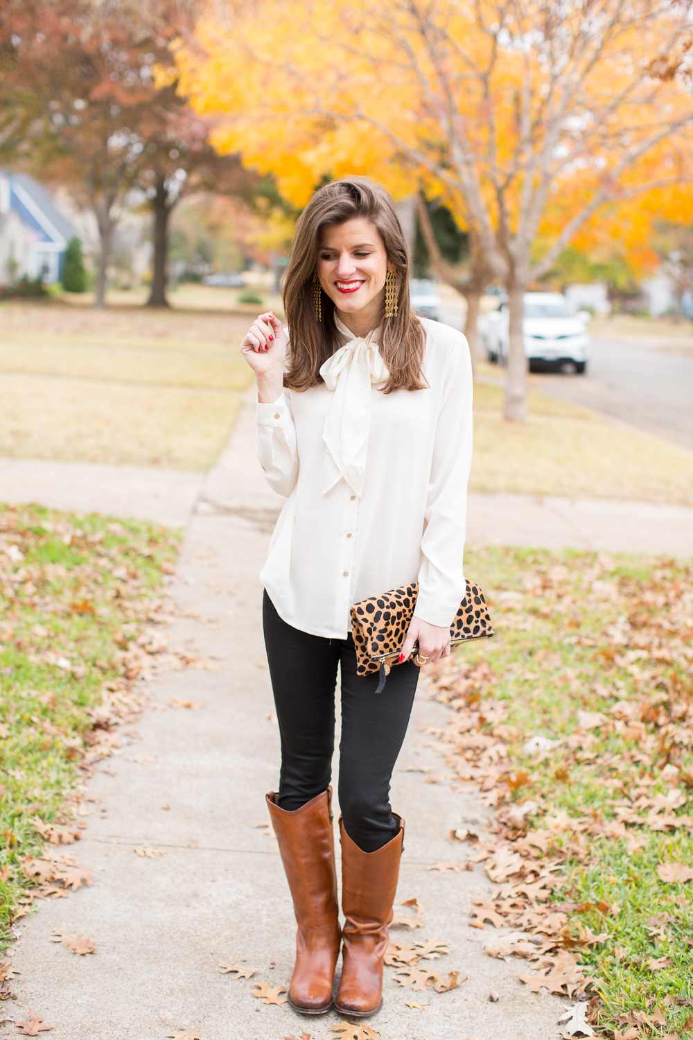 black jeans, white tie neck blouse, leopard clutch