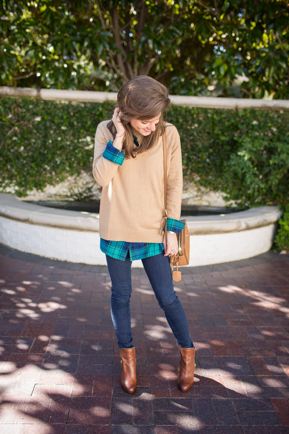 tan sweater over green and blue plaid shirt