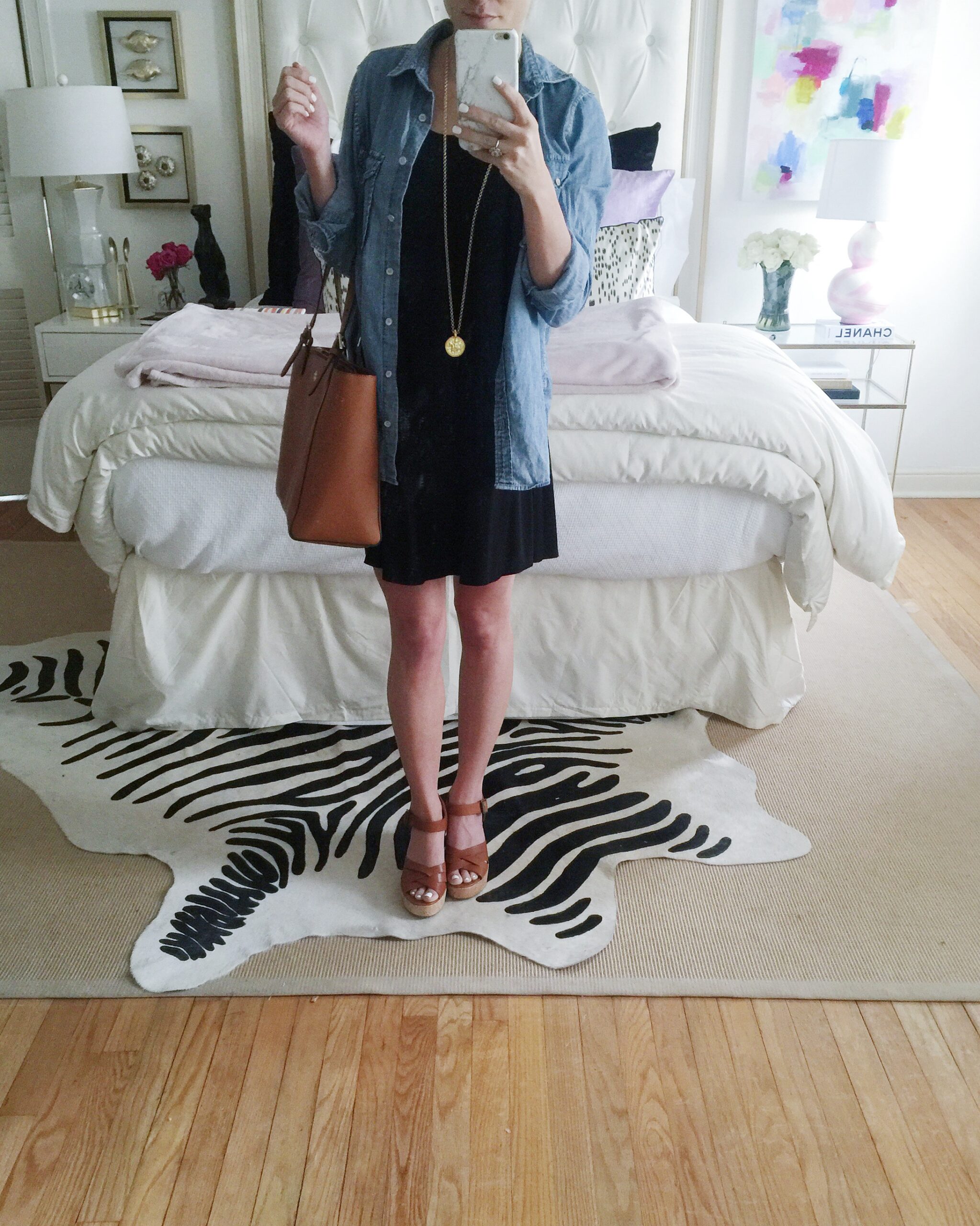 @brightonkeller mirror selfie wearing black mini swing dress with chambray worn as a cardigan and gold pendant necklace