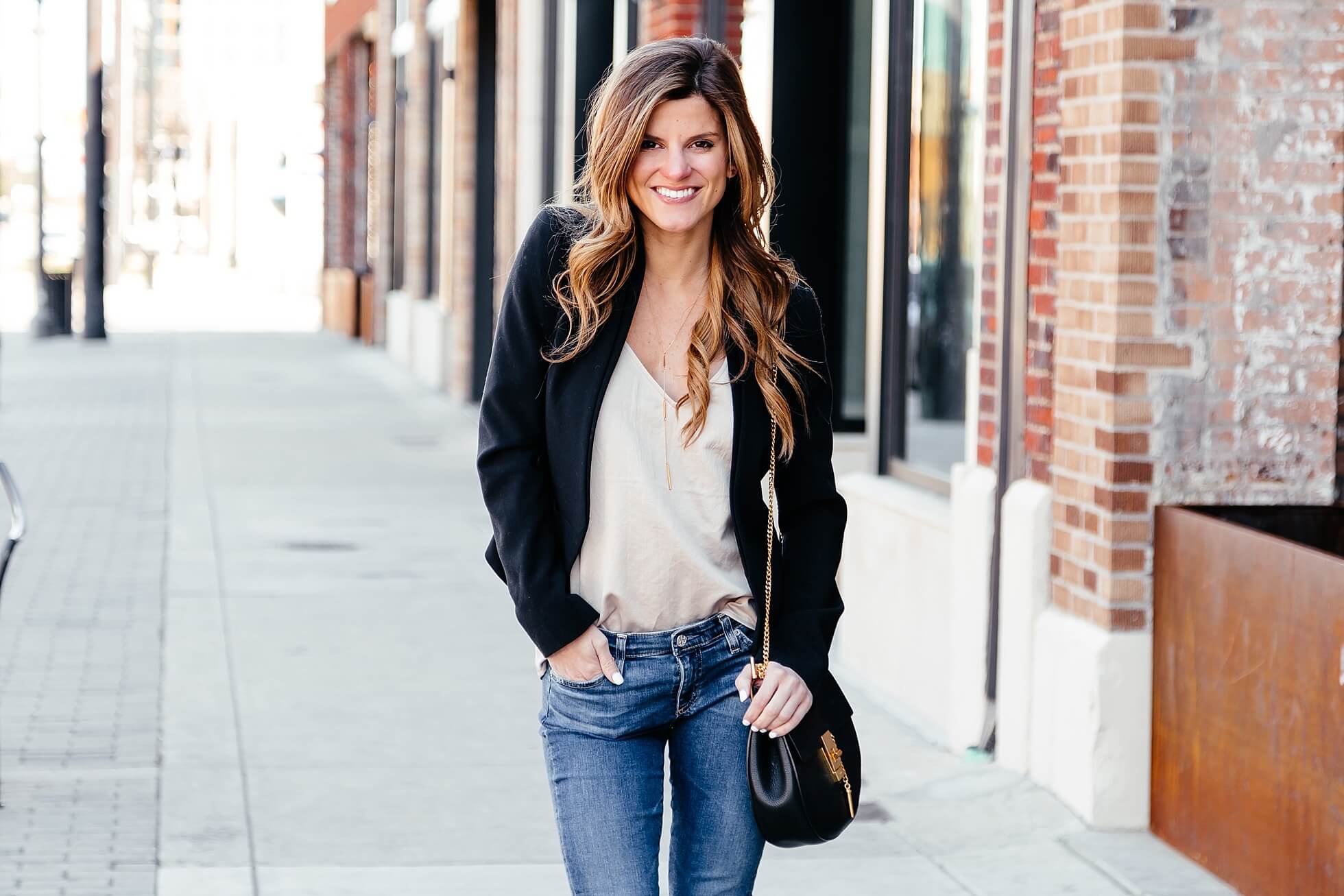 Brighton keller wearing t-back satin tank with black blazer and jeans 