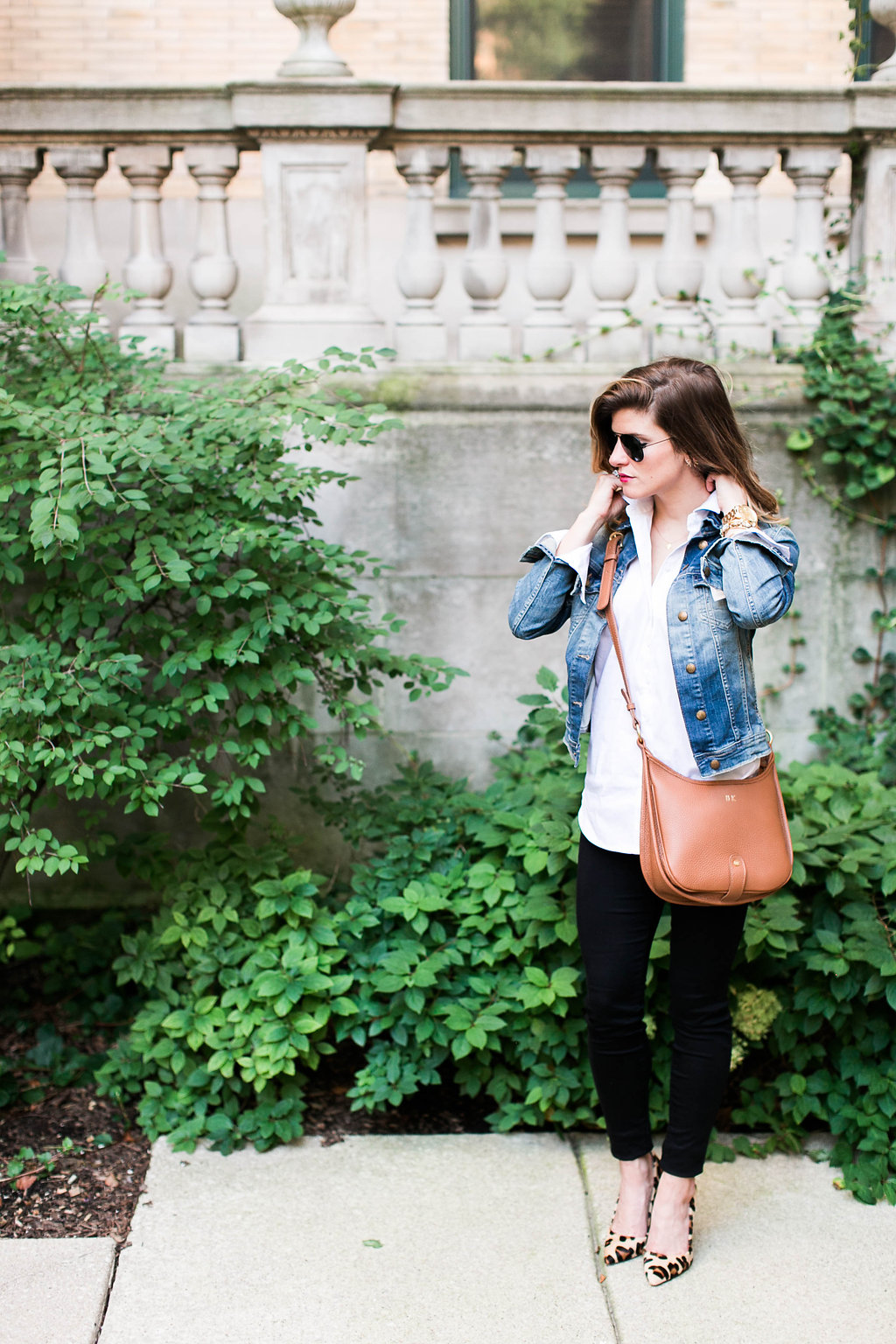 what to wear with a jean jacket, denim jacket and white button down and brown leather crossbody and leopard pointed toe heels