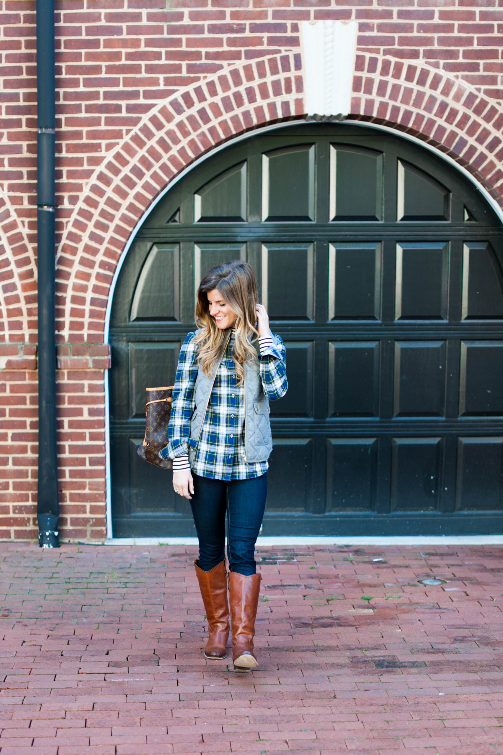 layered stripes and plaid under a puffer vest