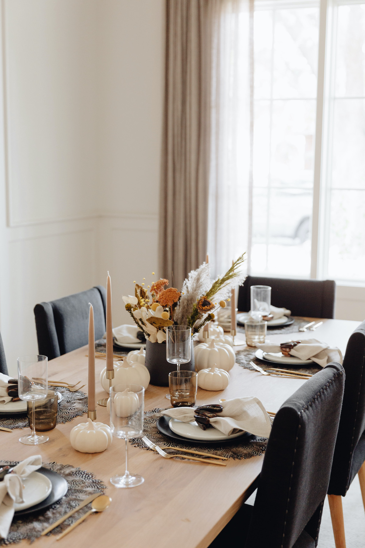 Brighton Butler Fall Tablescape with black and white plates and feather placemat, black plates, taupe table, fall themed dinner table