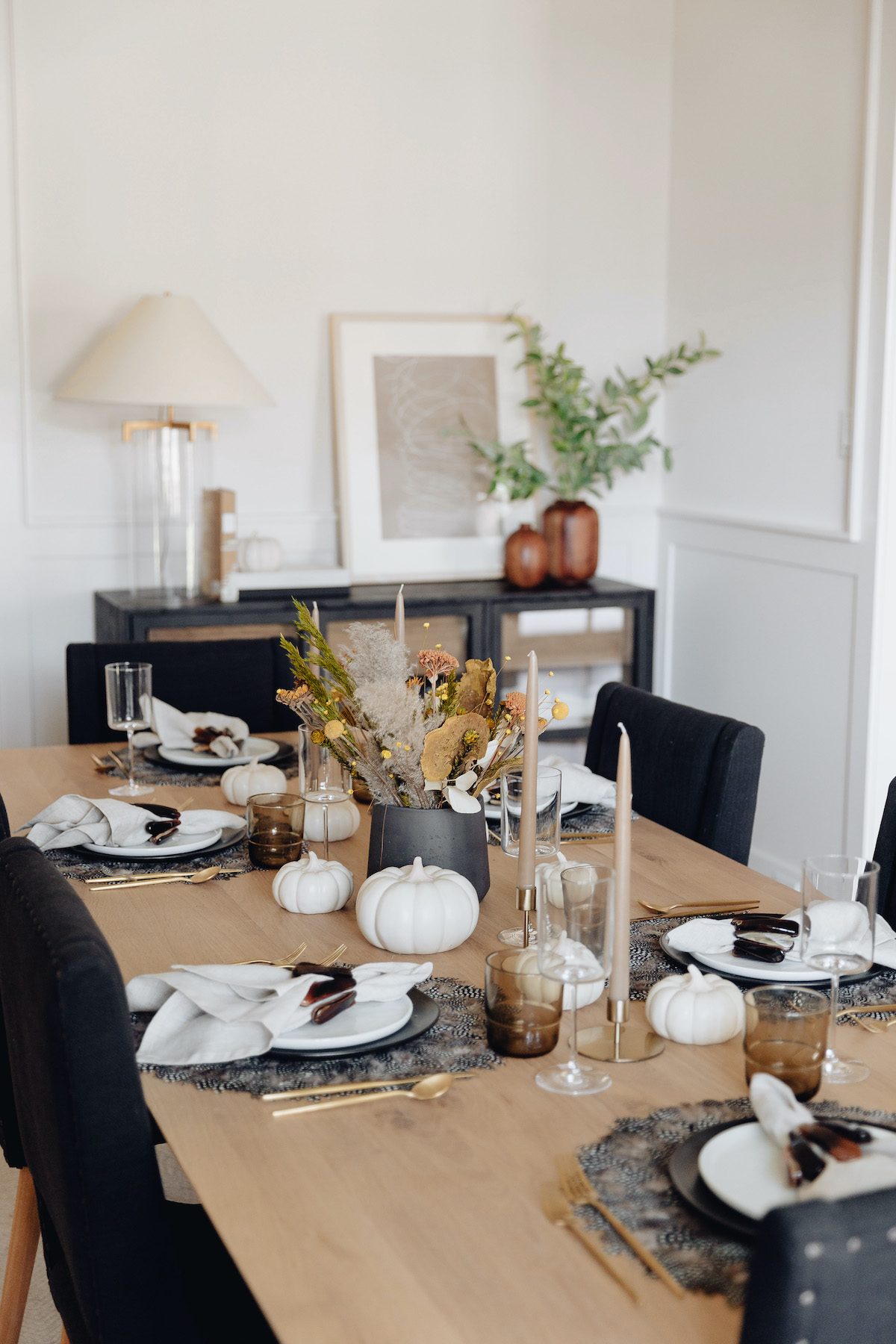 Brighton Butler Fall table with black and white plates and feather placemat, dried flower arrangement 