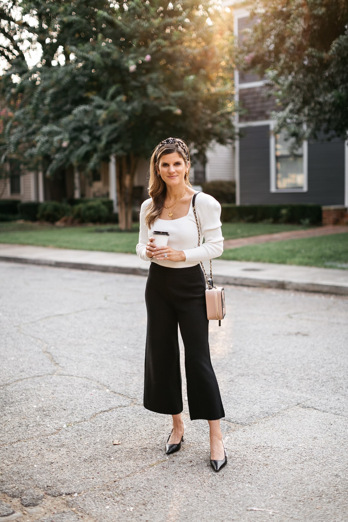 Brighton Butler wearing black sweater pants with white longsleeve and anthropolgie headband