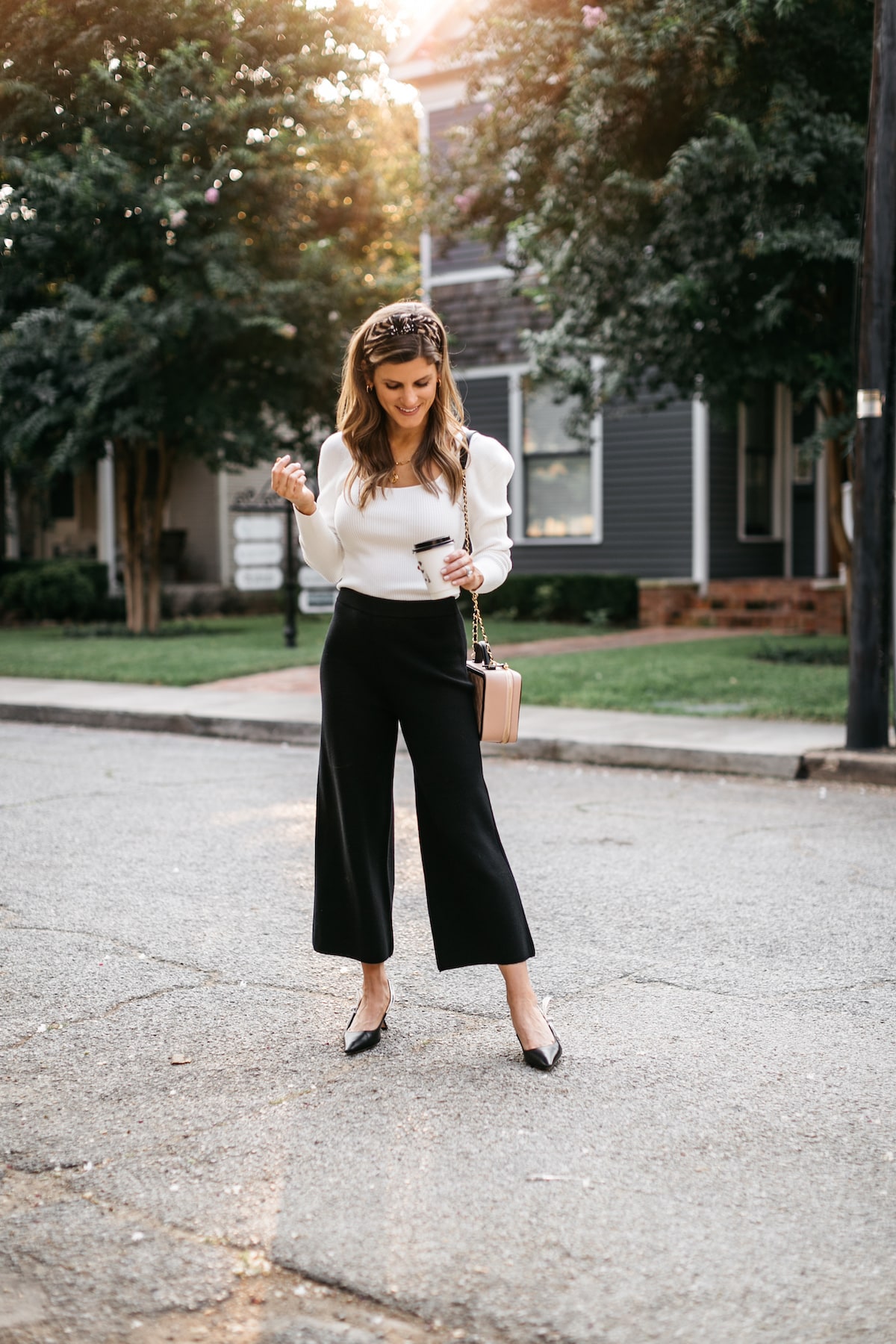 Brighton Butler wearing black sweater pants with white longsleeve and anthropolgie headband