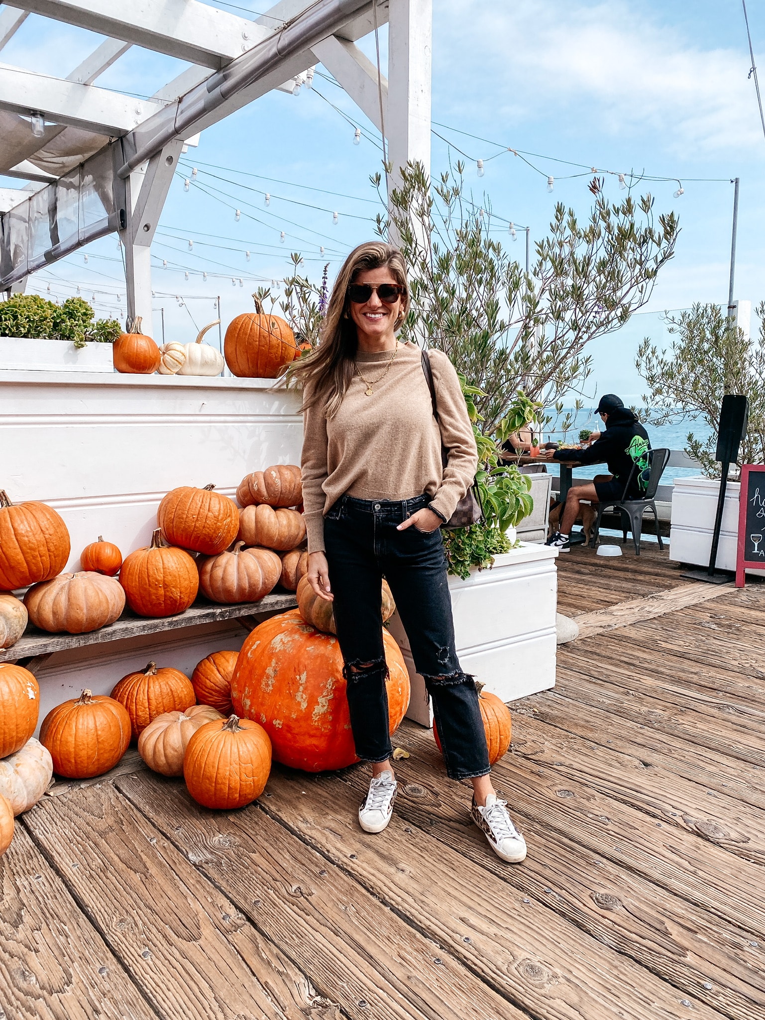 Brighton Butler wearing sweater and boyfriend jeans and golden goose sneakers