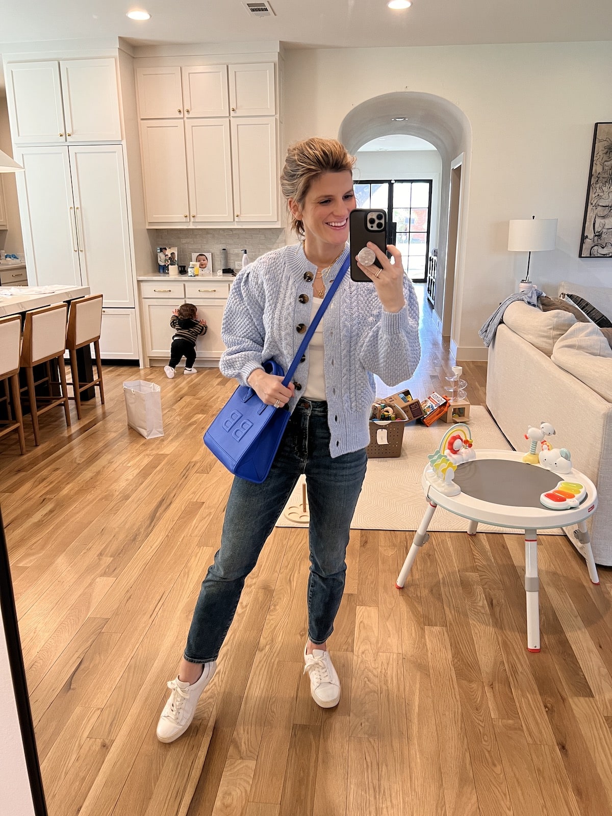 Brighton Butler wearing target blue cardigan with leatherology blue tote