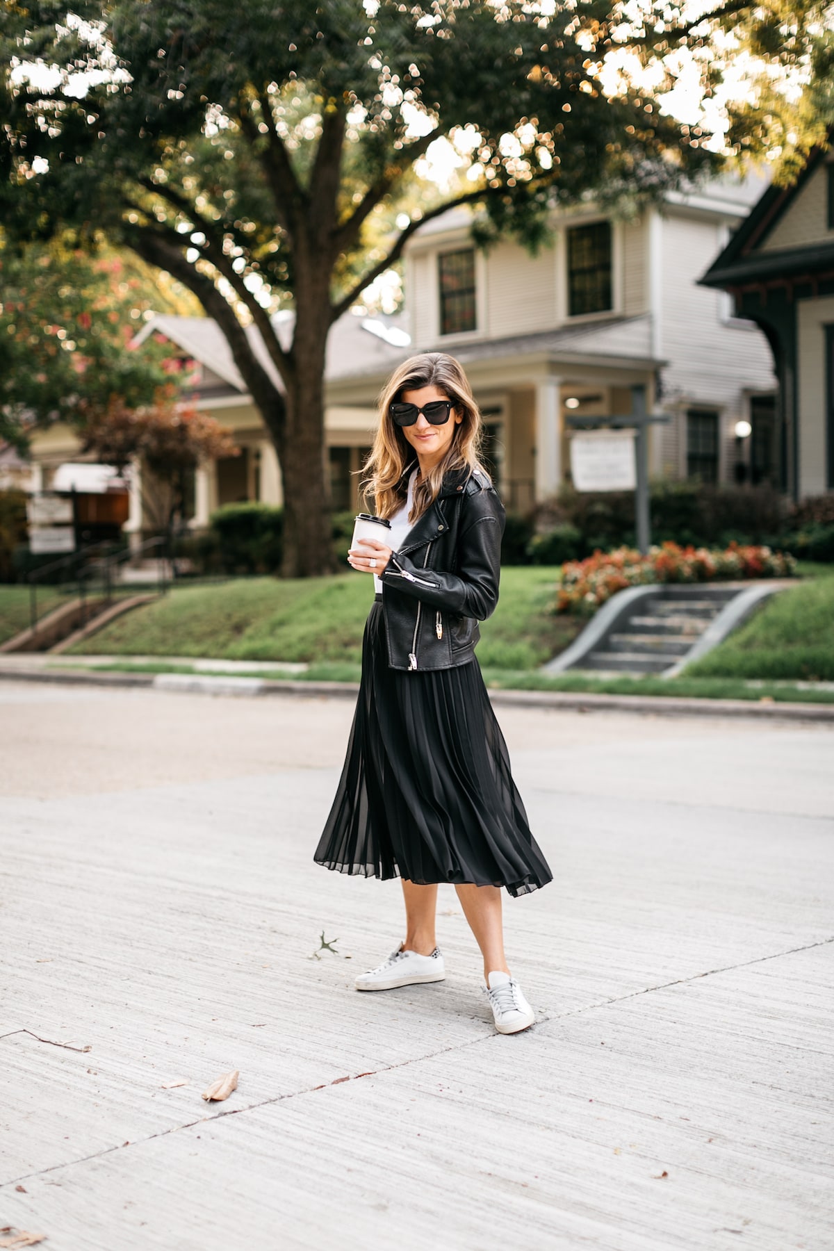 Brighton Butler wearing white tee with moto jacket and black midi skirt