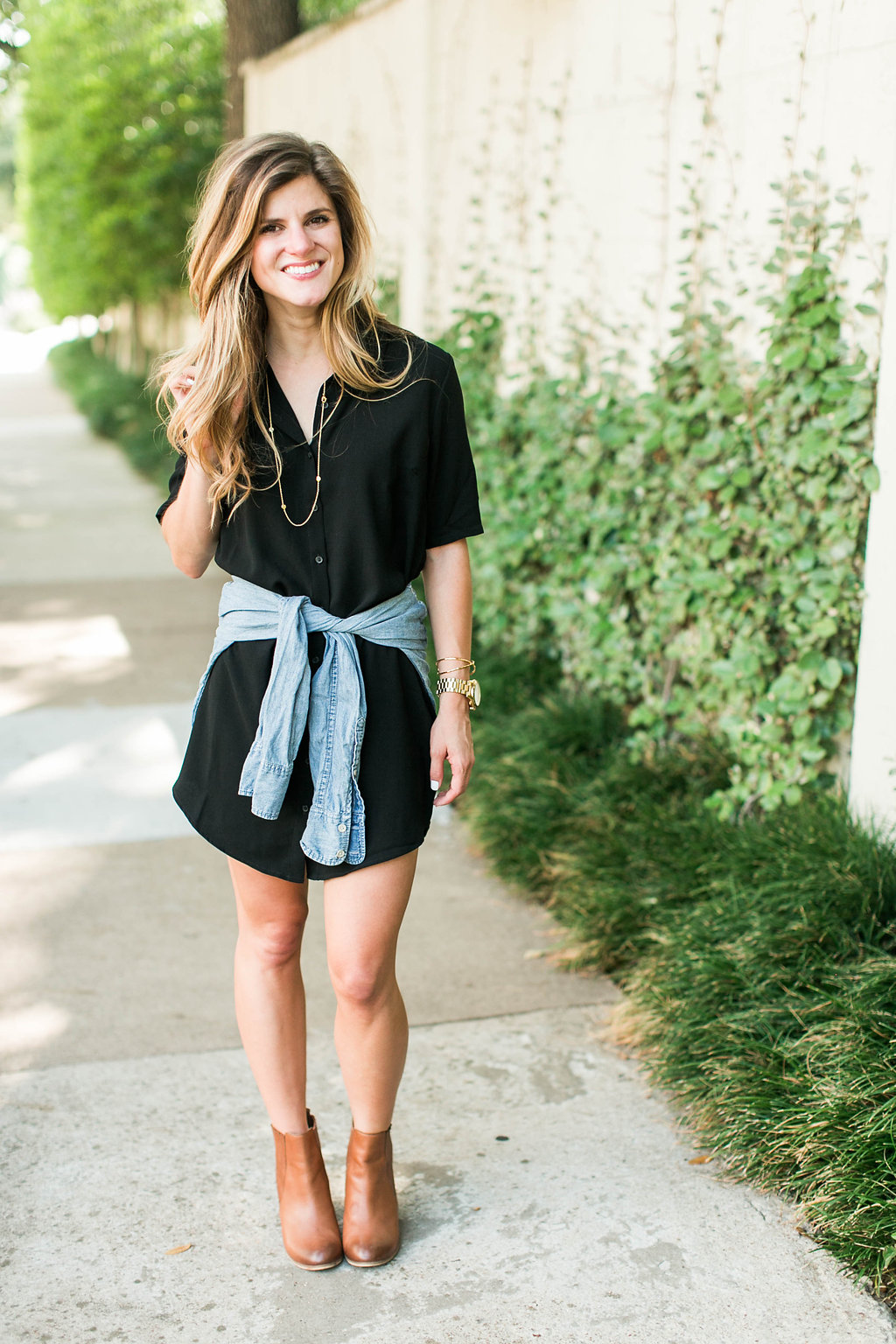 Brighton keller wearing black shirtdress with denim shirt tied around waist