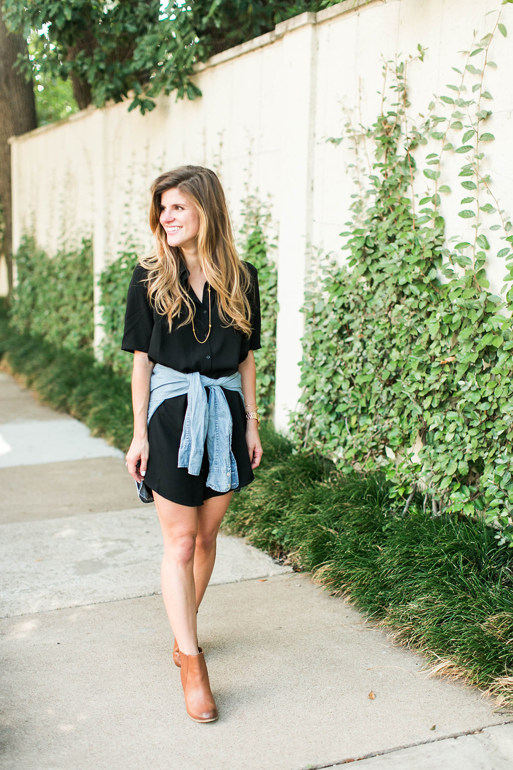 Brighton keller wearing black shirtdress with denim shirt tied around waist