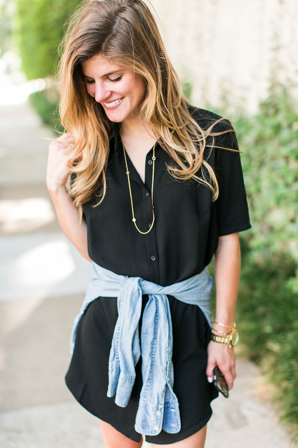 Brighton keller wearing black shirtdress with denim shirt tied around waist