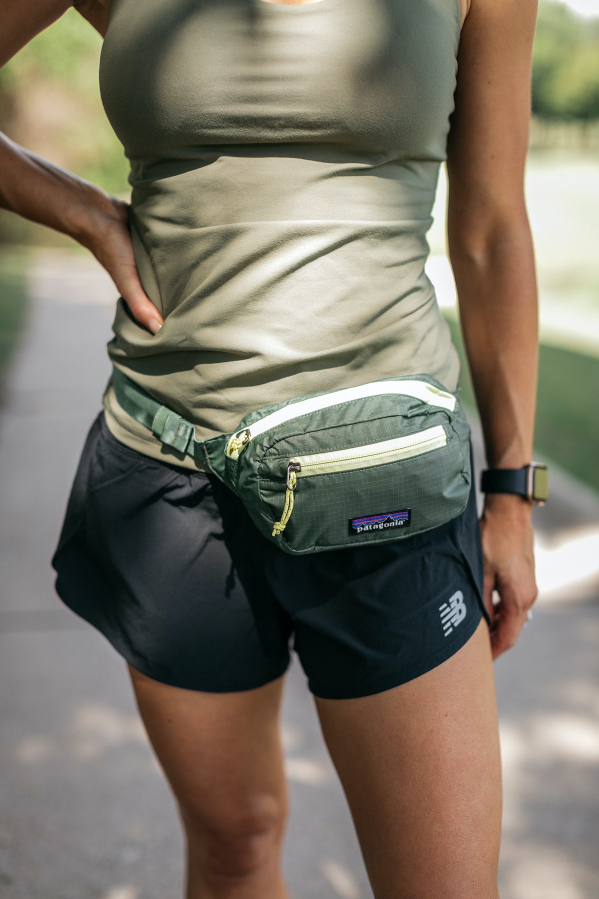 Brighton Butler wearing green tank with fanny pack for Backcountry