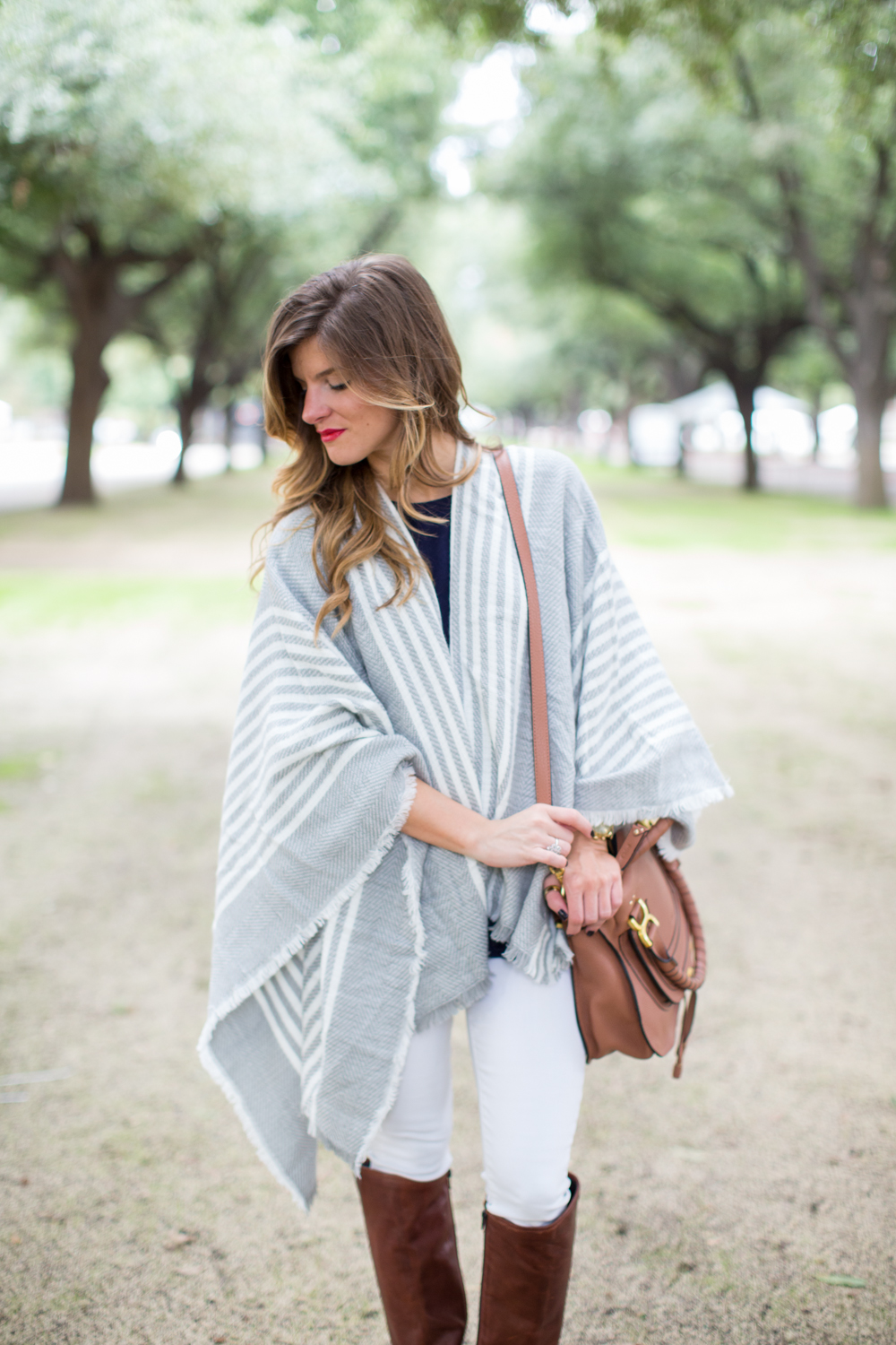 Grey poncho white jeans and brown riding boots