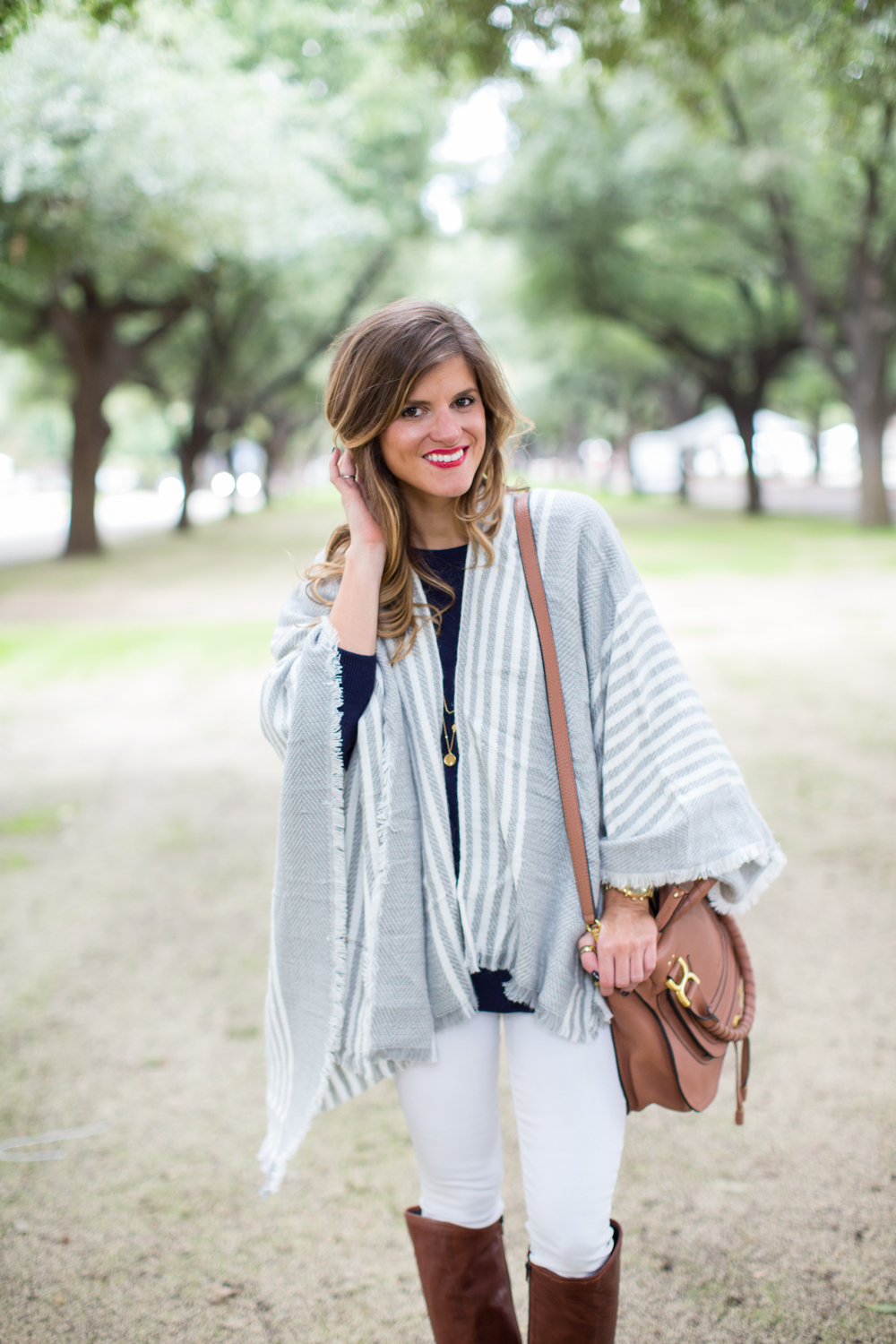 Grey poncho white jeans and brown riding boots