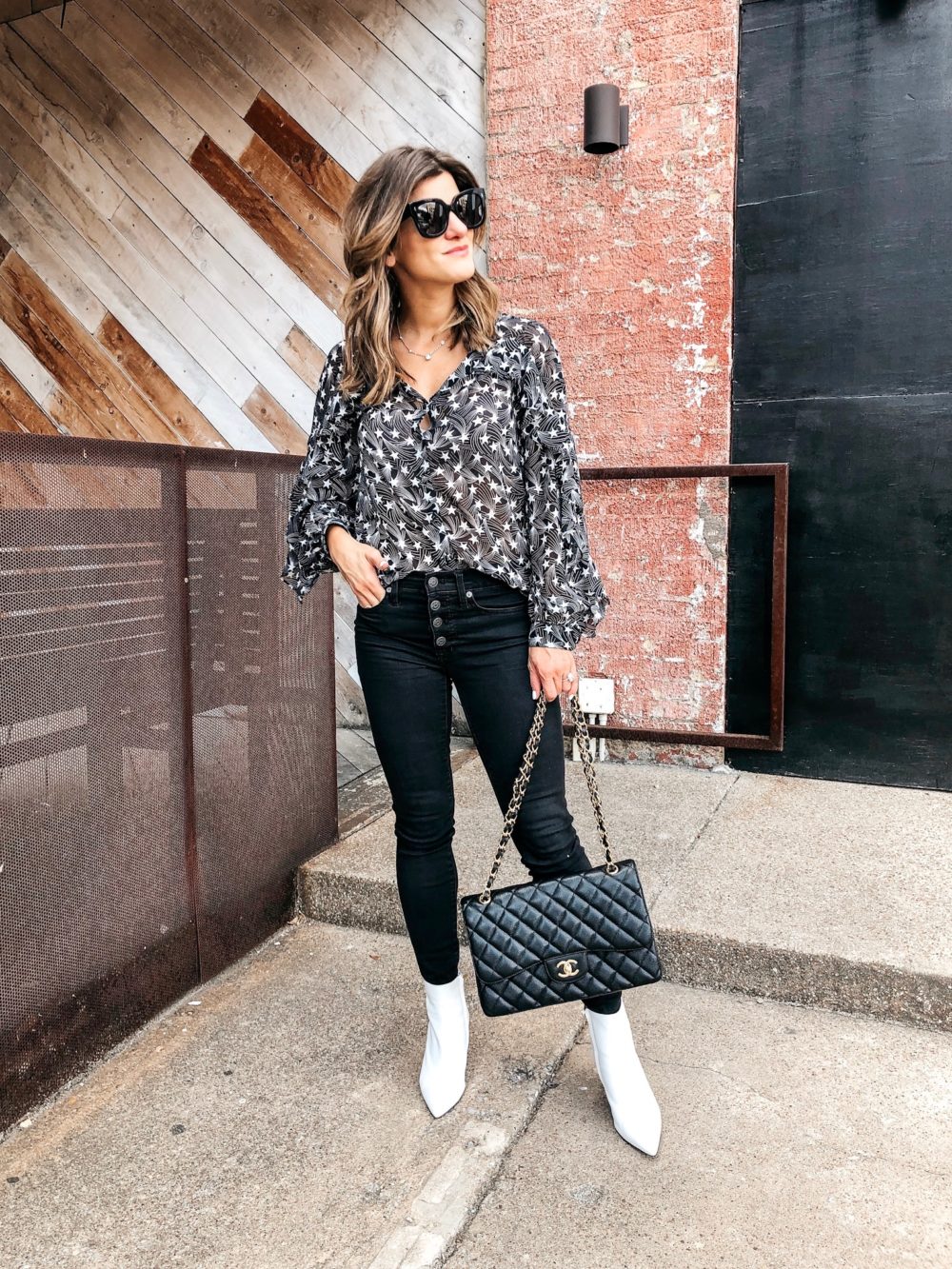 transitional fall outfit on brighton keller star print top with black jeans, white booties