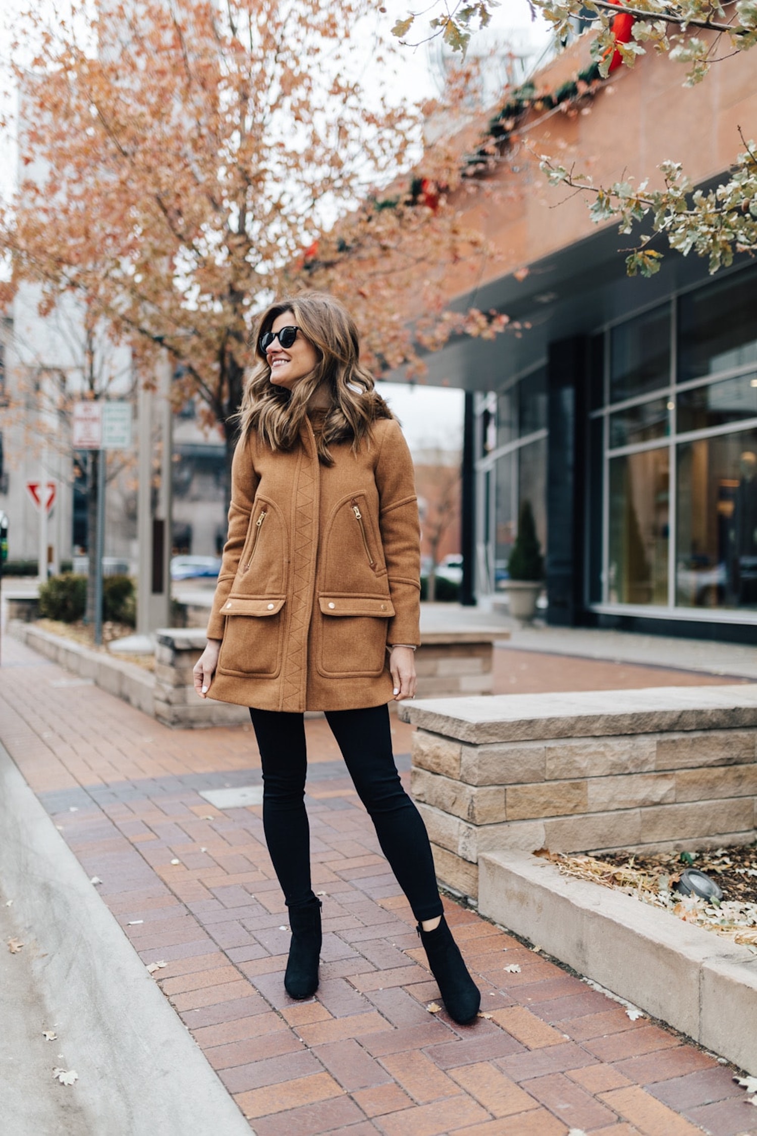 Brighton Butler wearing a tan crew coat and black leggings