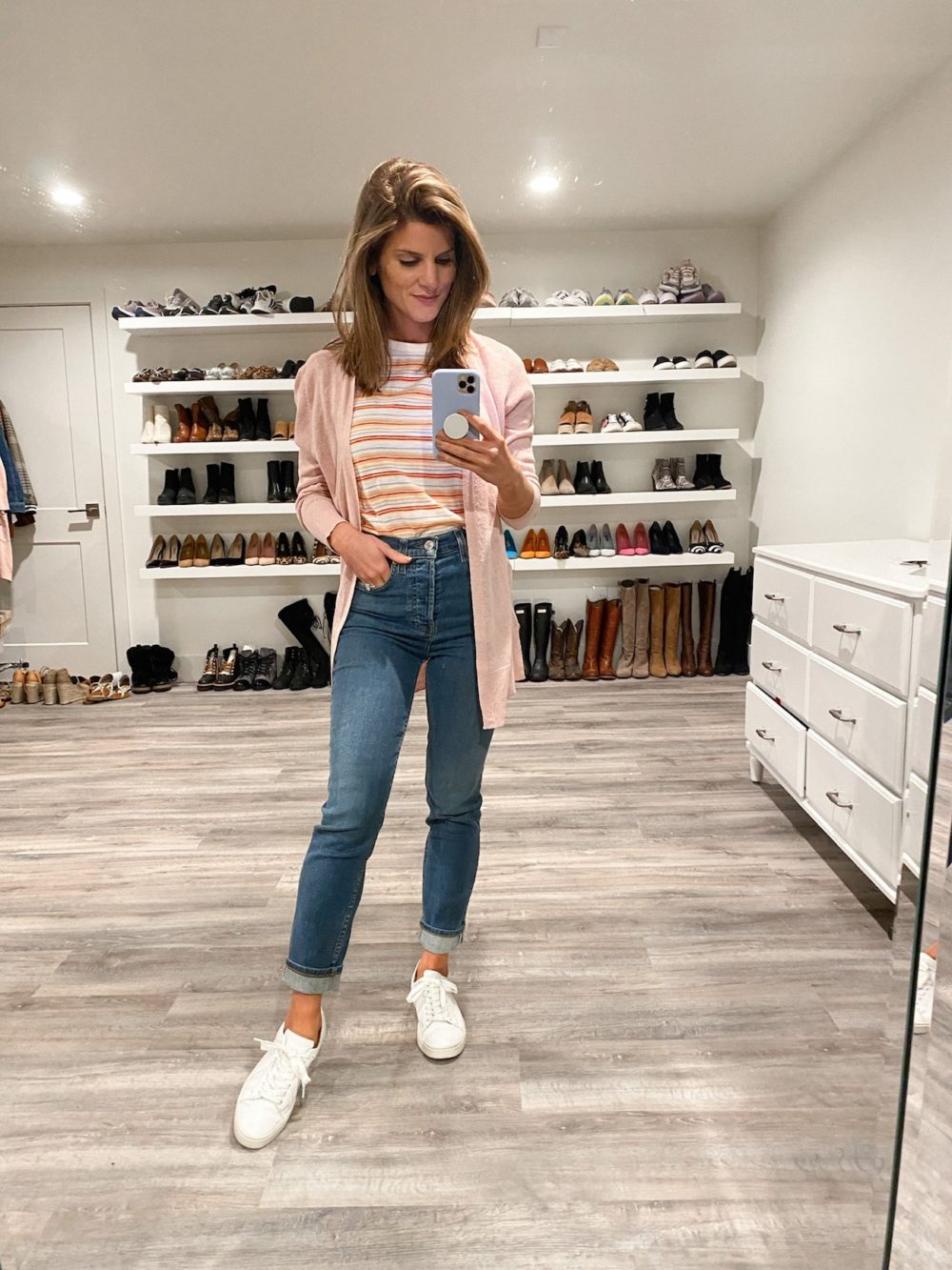 Brighton Keller wearing jeans, striped tee, pink cardigan and white sneakers