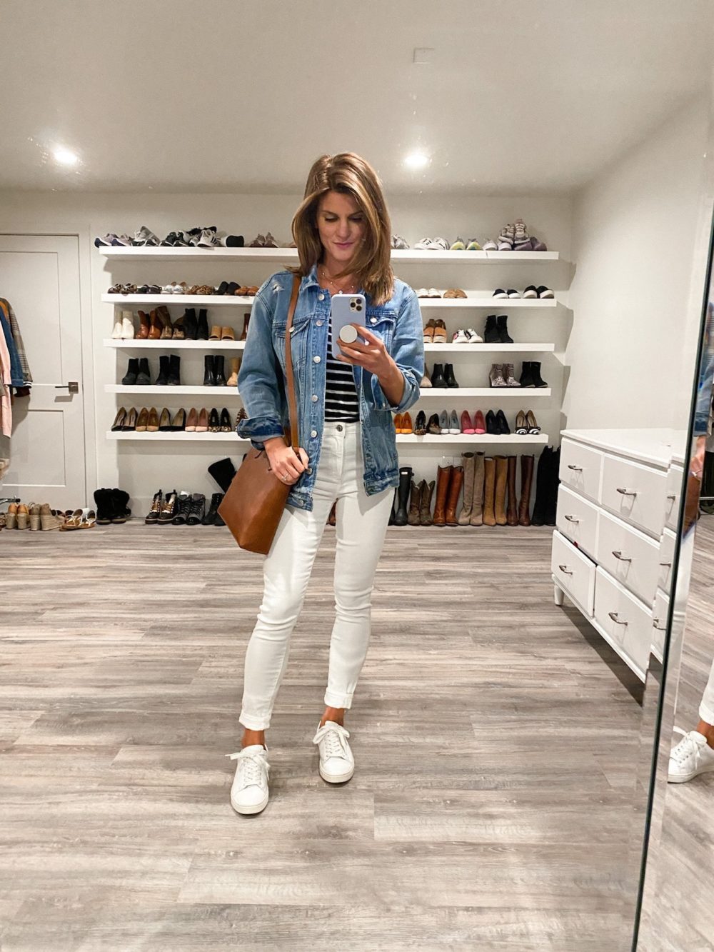 Brighton Keller wearing striped shirt, jean jacket, white pants and white sneakers