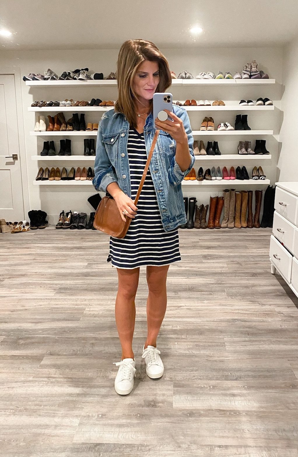 Brighton Keller wearing striped dress, jean jacket, white sneakers and brown purse