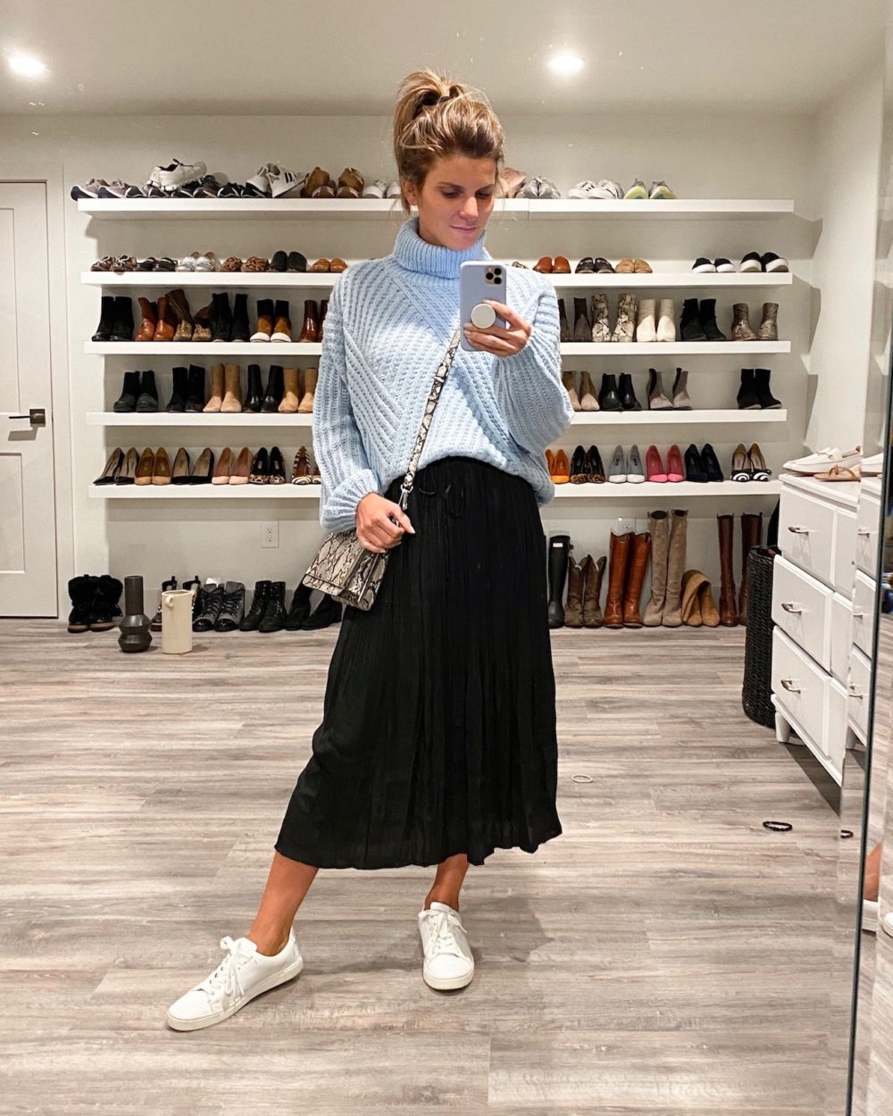 Brighton Keller wearing oversized blue sweater, midi skirt and white sneakers