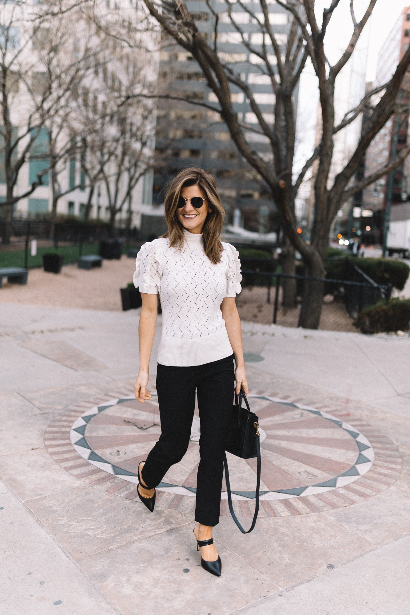 Brighton Keller wearing white sweater top, black work pants and black pumps