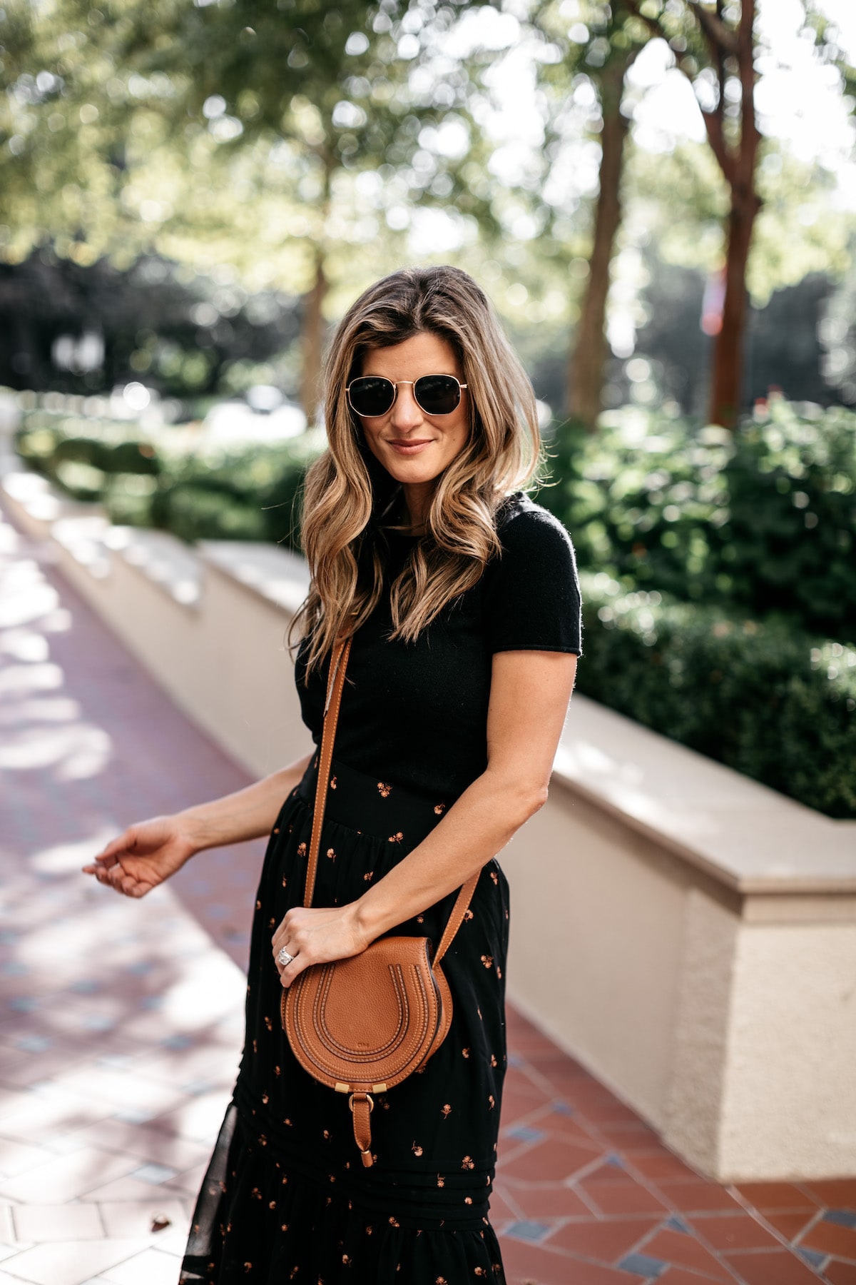 Brighton Butler wearing Madewell Fall Floral Skirt with Black tee and Frye white sneakers