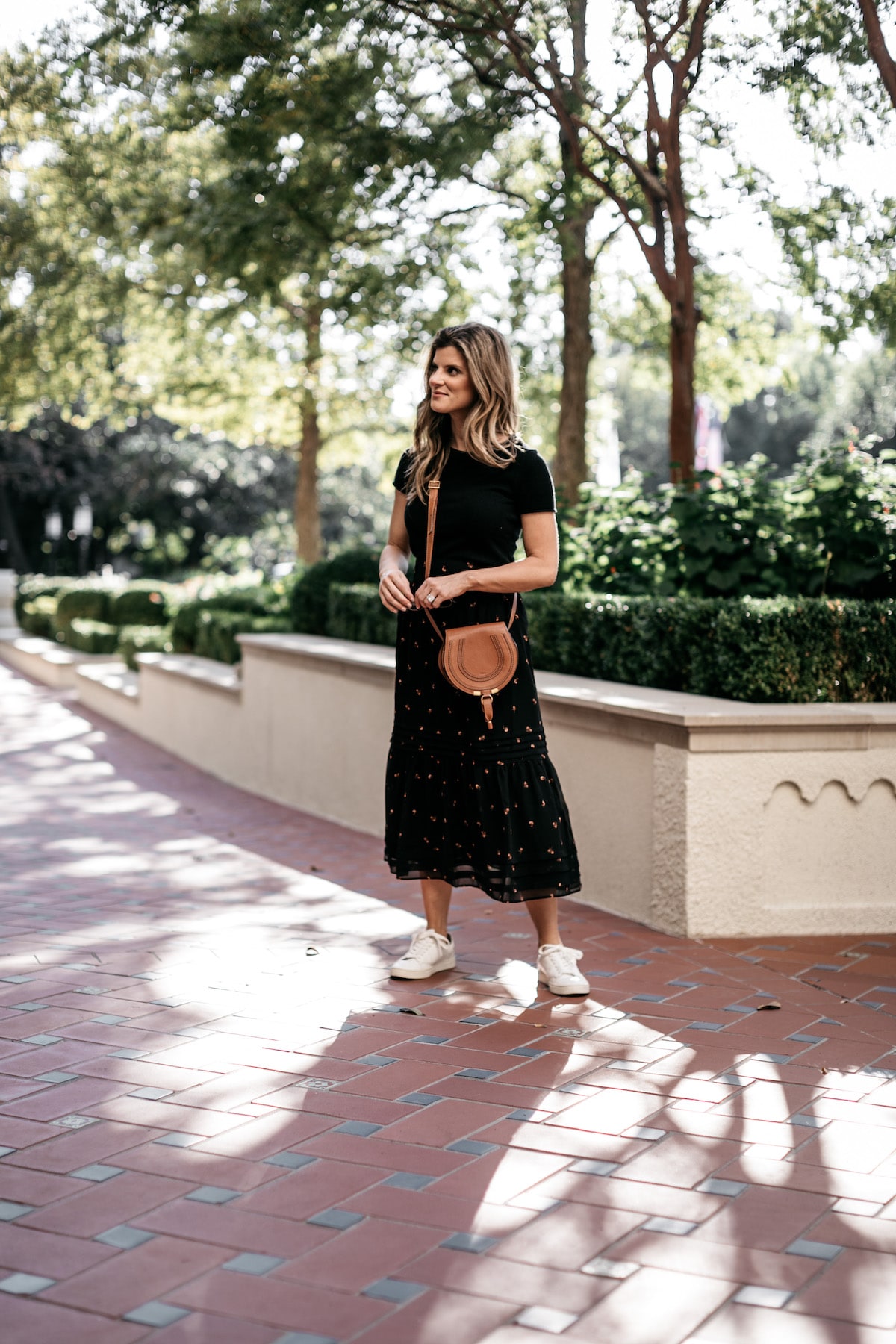 Brighton Butler wearing Madewell Fall Floral Skirt with Black tee and Frye white sneakers