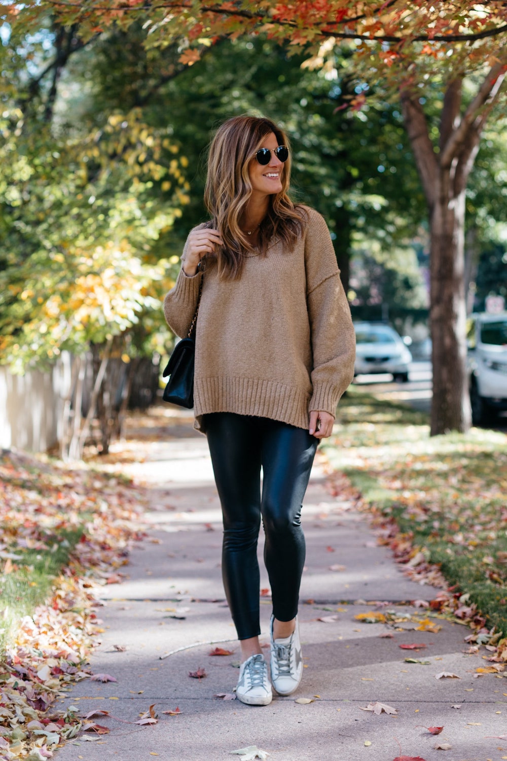 Brighton butler wearing commando faux leather leggings with oversized sweater and sneakers, leather leggings outfit