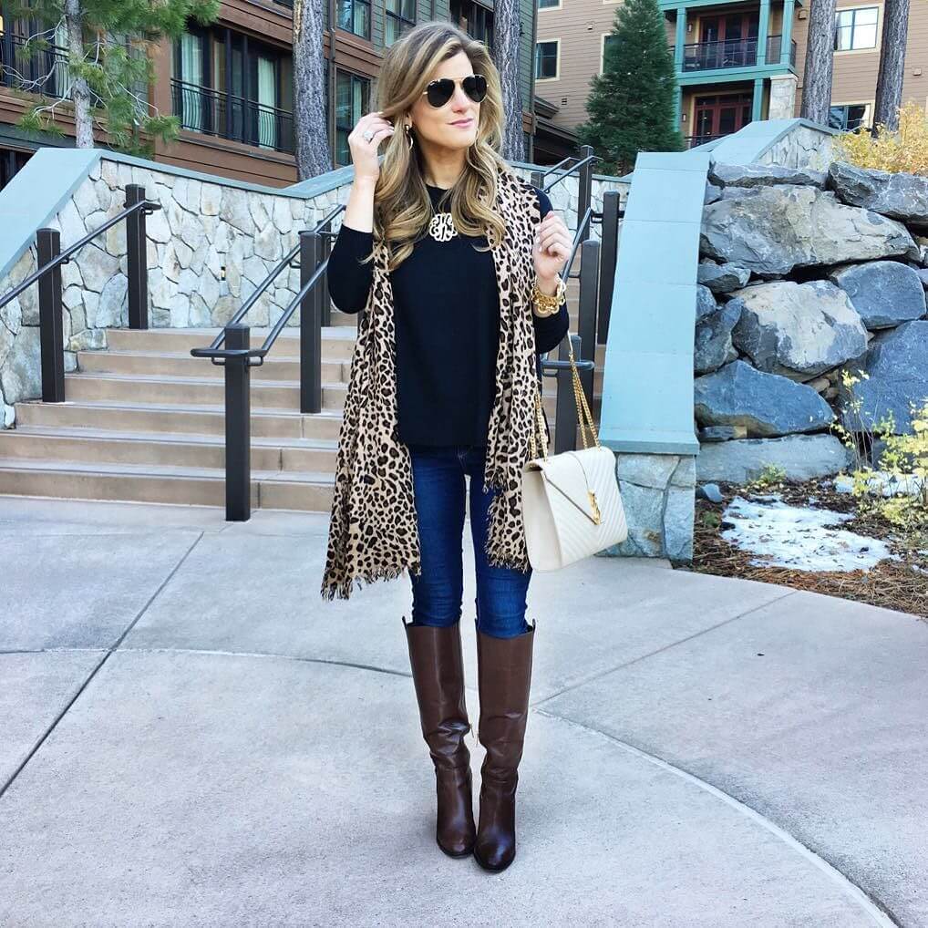 brighton keller wearing black sweater leopard scarf and riding boots