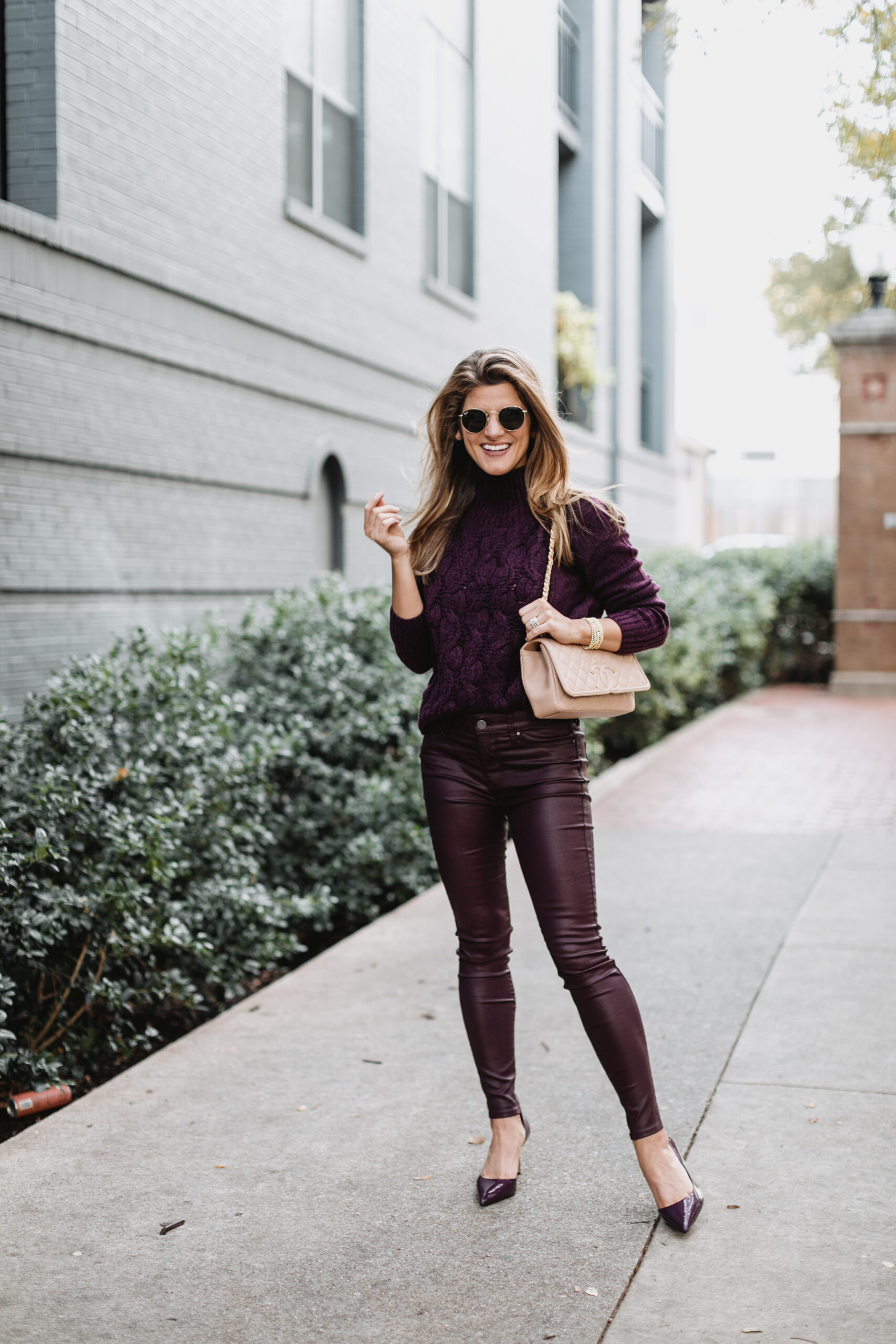 Brighton Butler wearing White House Black Market purple patent pants with purple sweater and pumps