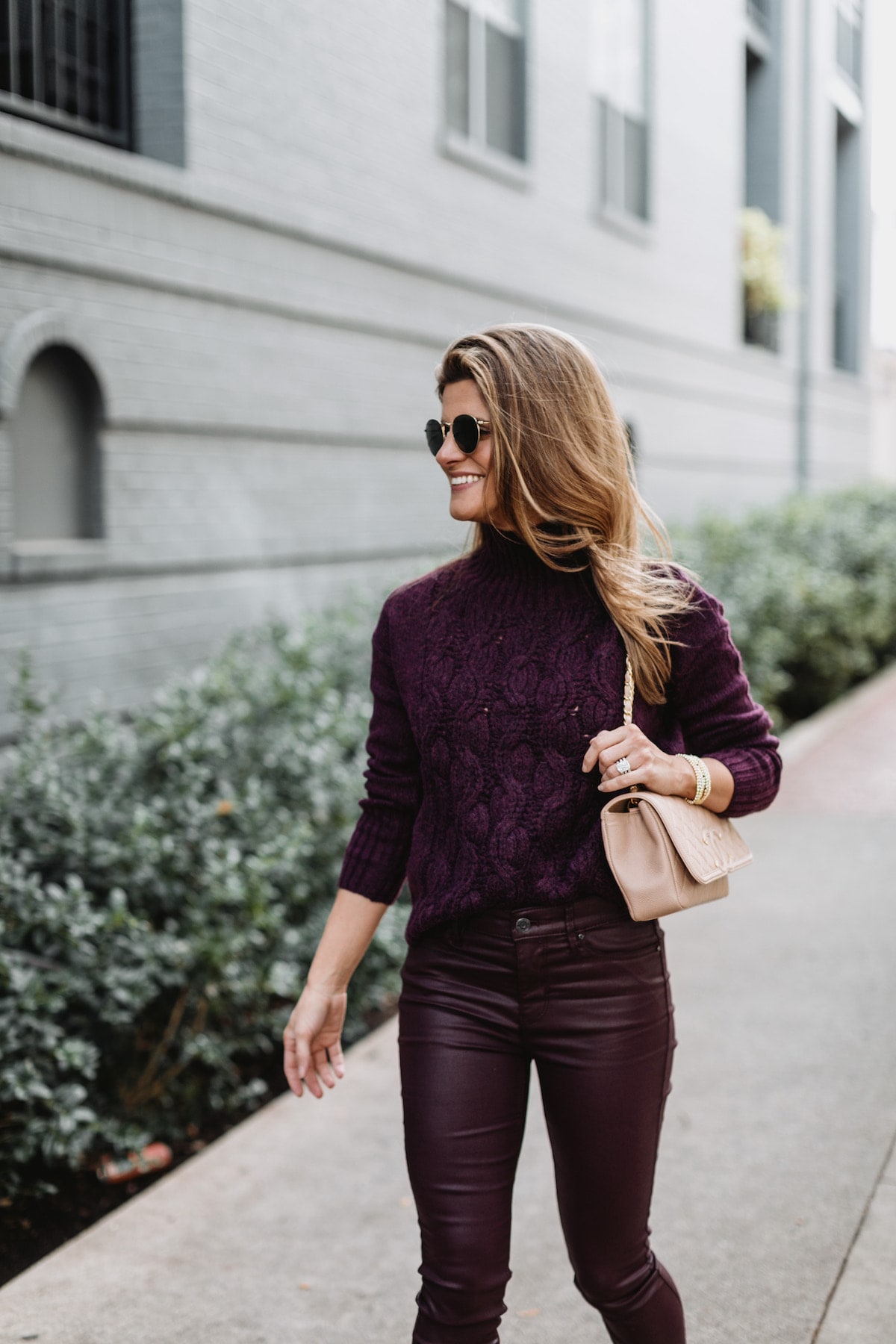 Brighton Butler wearing White House Black Market purple patent pants with purple sweater and pumps