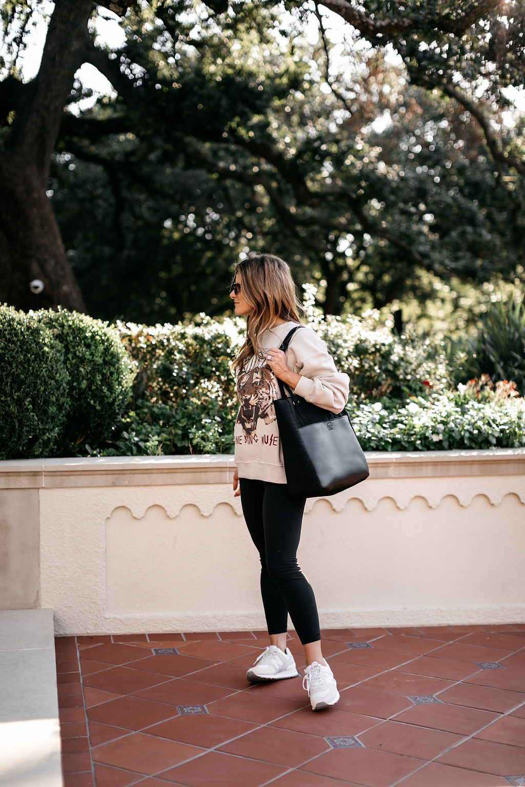 athleisure outfit graphic sweatshirt, black leggings, new balance sneakers, computer bag 15