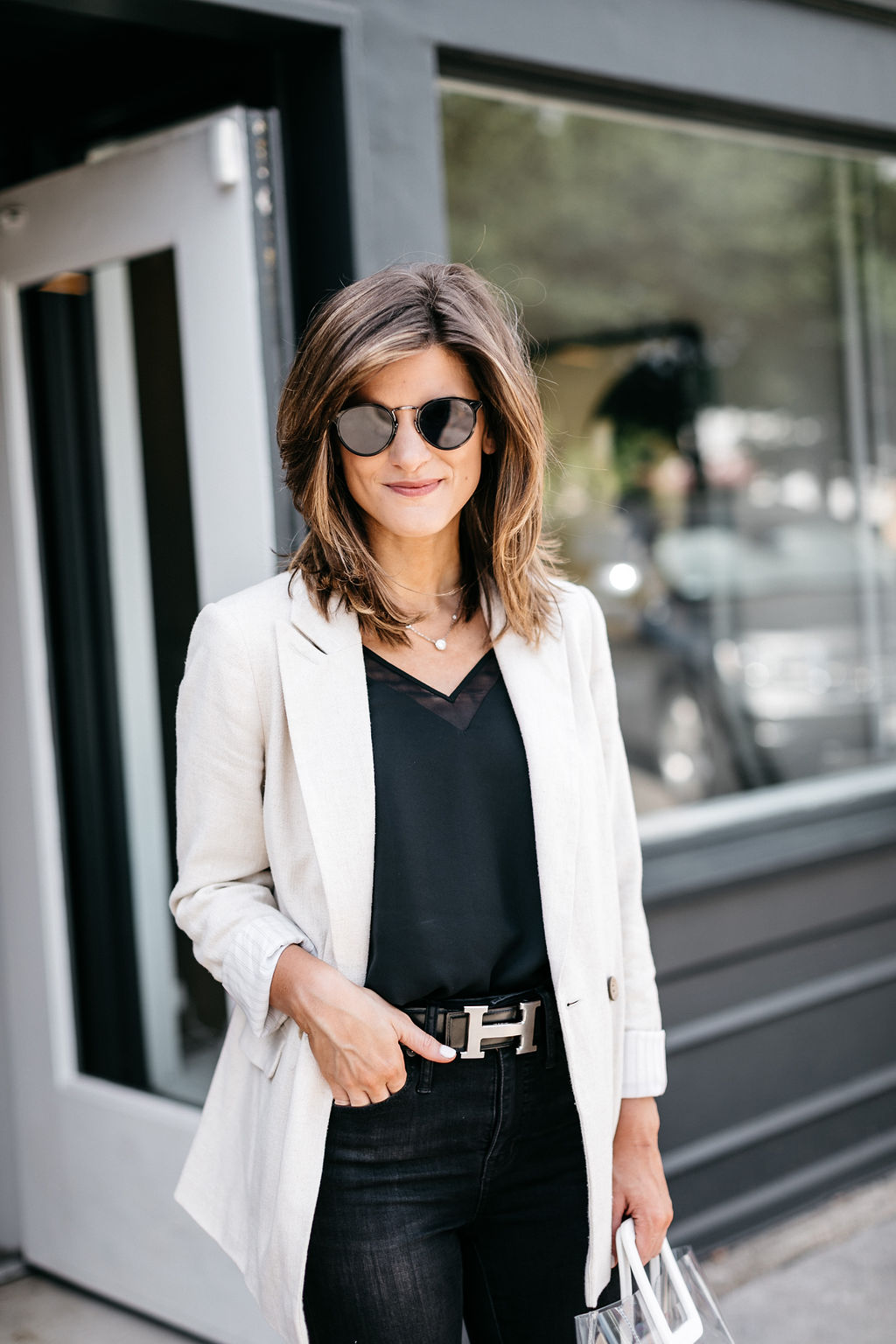 brighton keller wearing all black outfit with Hermes silver belt linen blazer