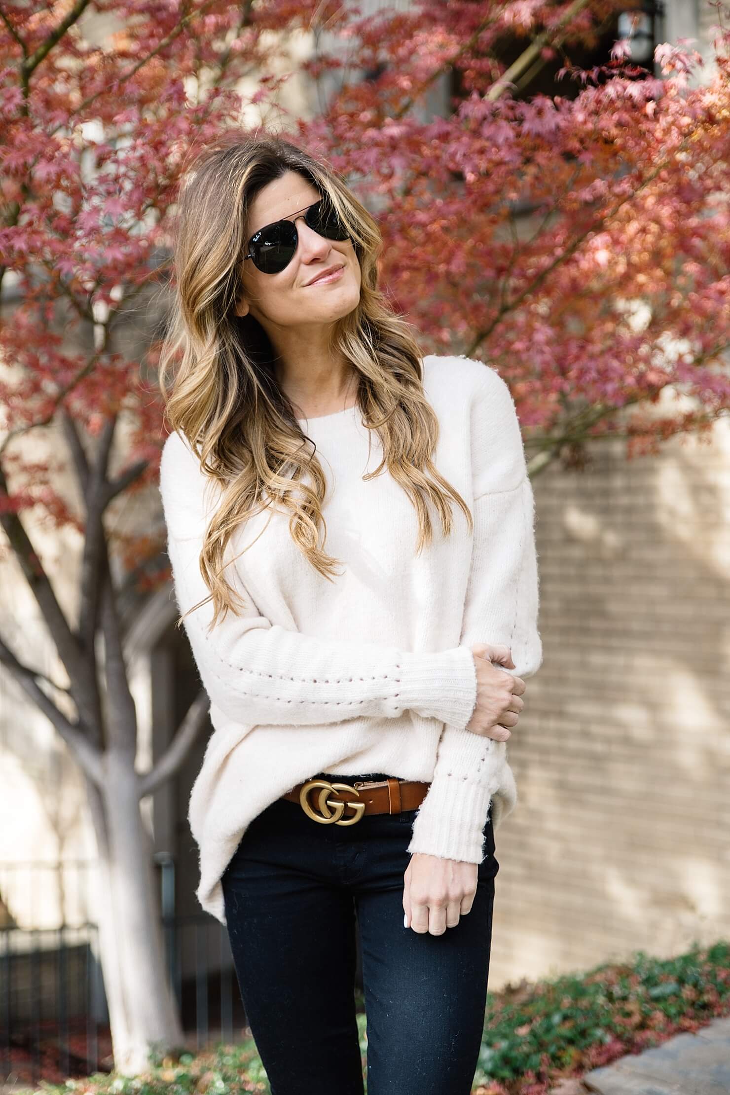 oversized cream sweater, brown and gold statement gucci logo belt, all black aviators, black jeans and brown belt