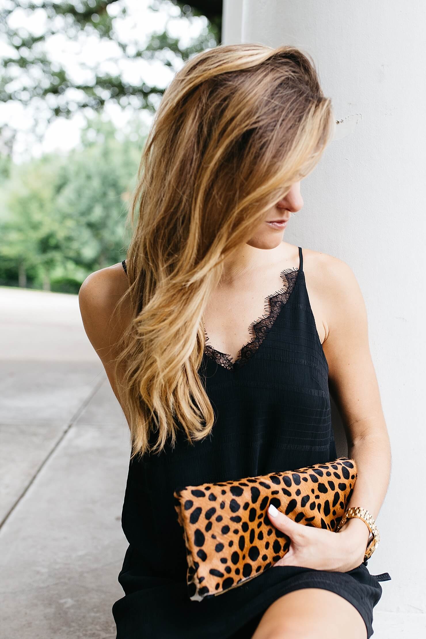 brighton keller wearing black lace trim slip dress with clare vivier leopard clutch