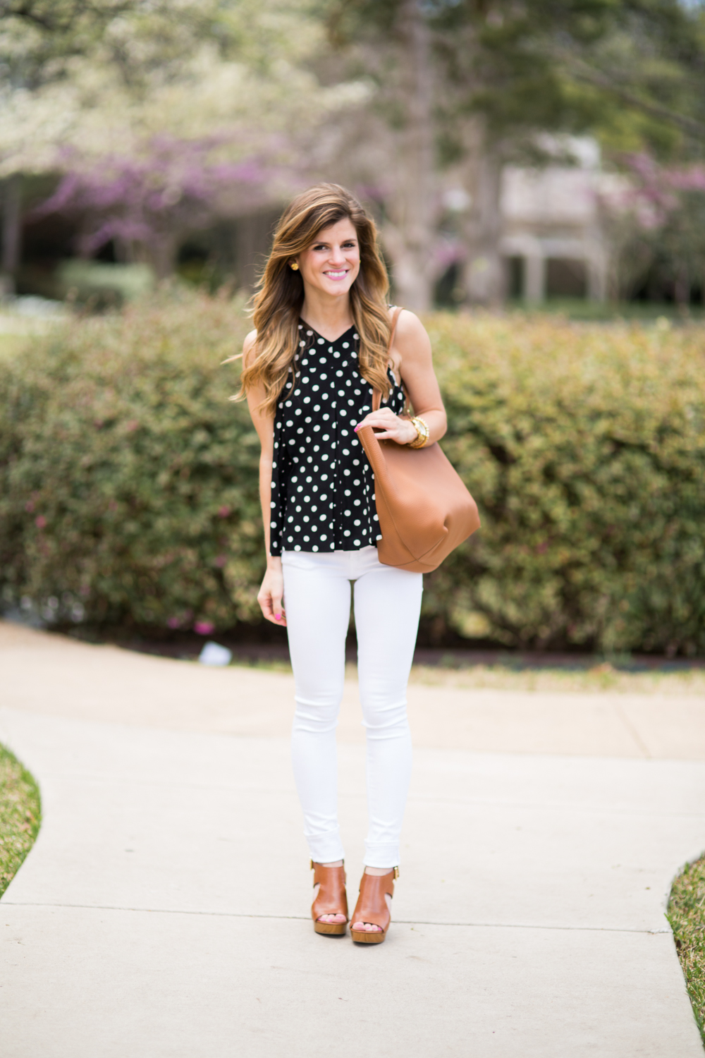 black and brown outfit - black and white polka dot shirt, white jeans, brown bag, brown wedges