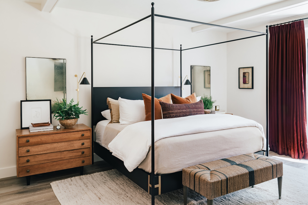 moody bedroom with black bed and neutral bedding