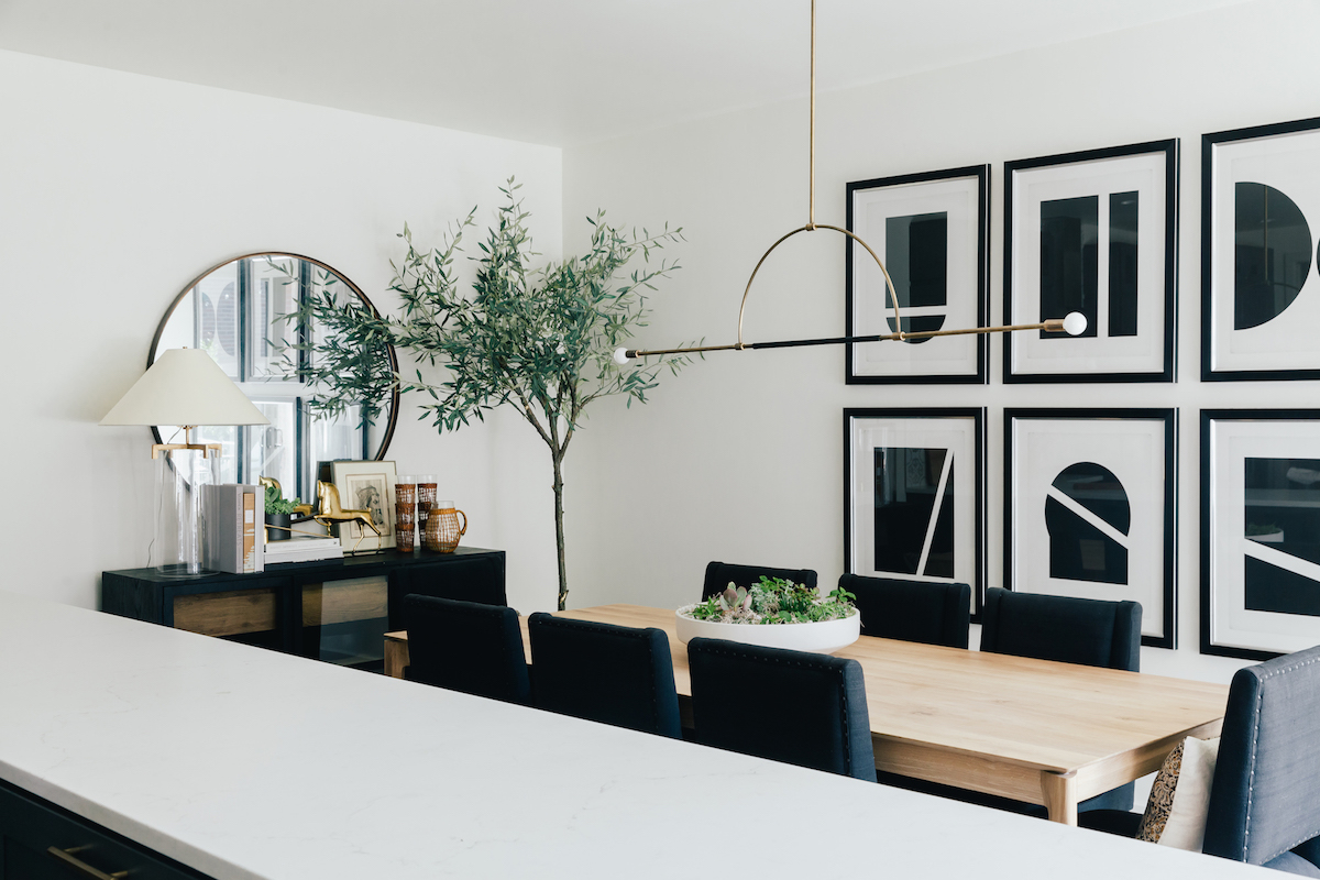 brighton butler denver dining room, black and white artwork, faux olive tree, circular mirror over sideboard