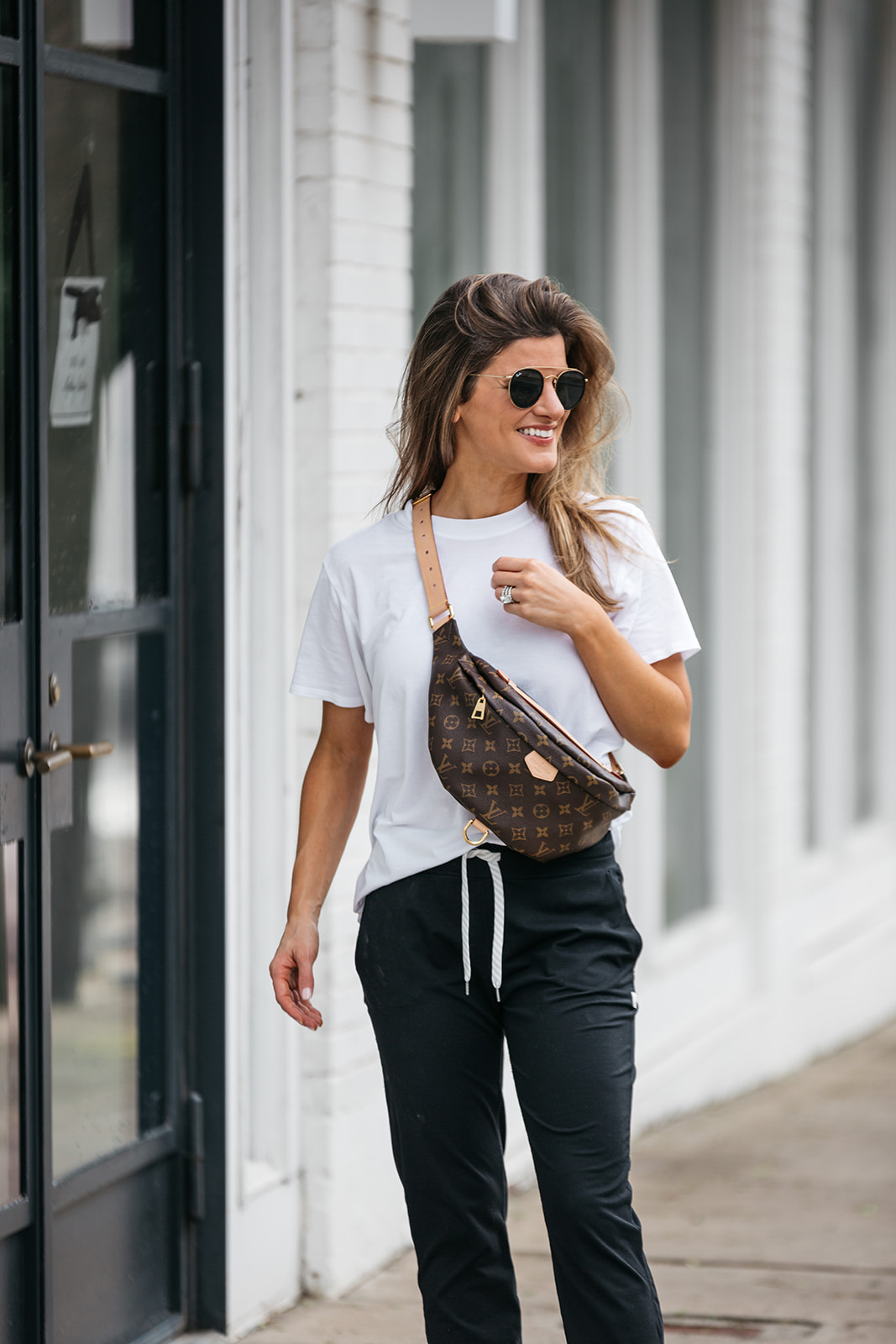 brighton butler wearing vuori joggers, all yours tee and louis vuitton bum bag