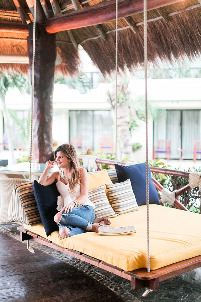 brightontheday sitting on swing bed at azul beach karisma hotel waering distressed denim