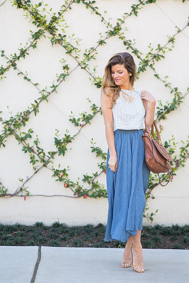 brightontheday wearing blue high-waisted midi skirt with linen crop top, gold bar necklace and stuart weitzman nudist heels