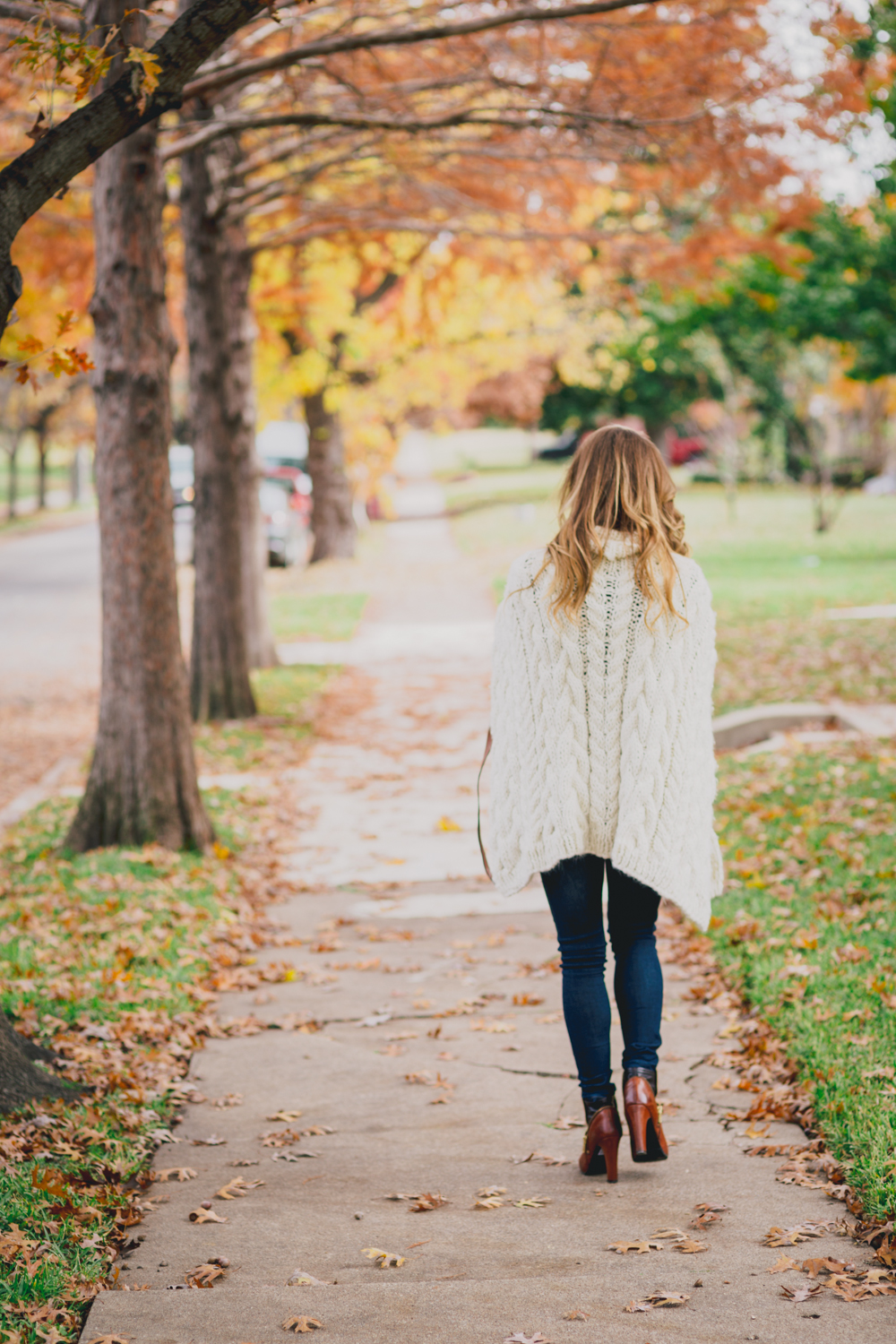 back view of cable knit poncho outfit with jeans