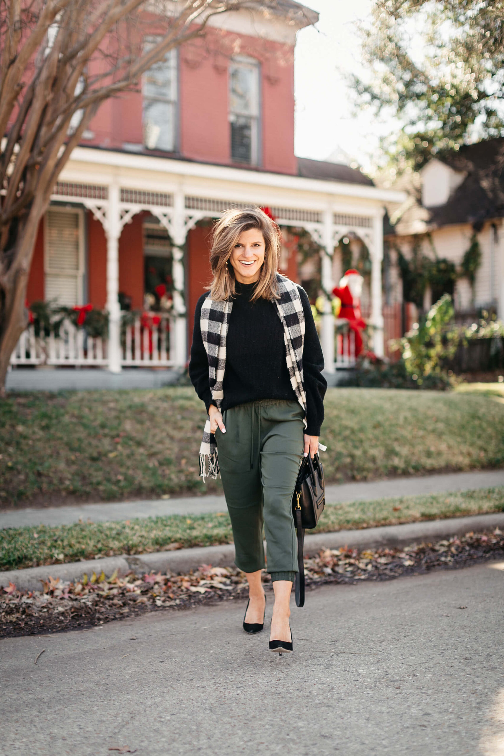 green joggers, black sweater, checkered scarf and cap