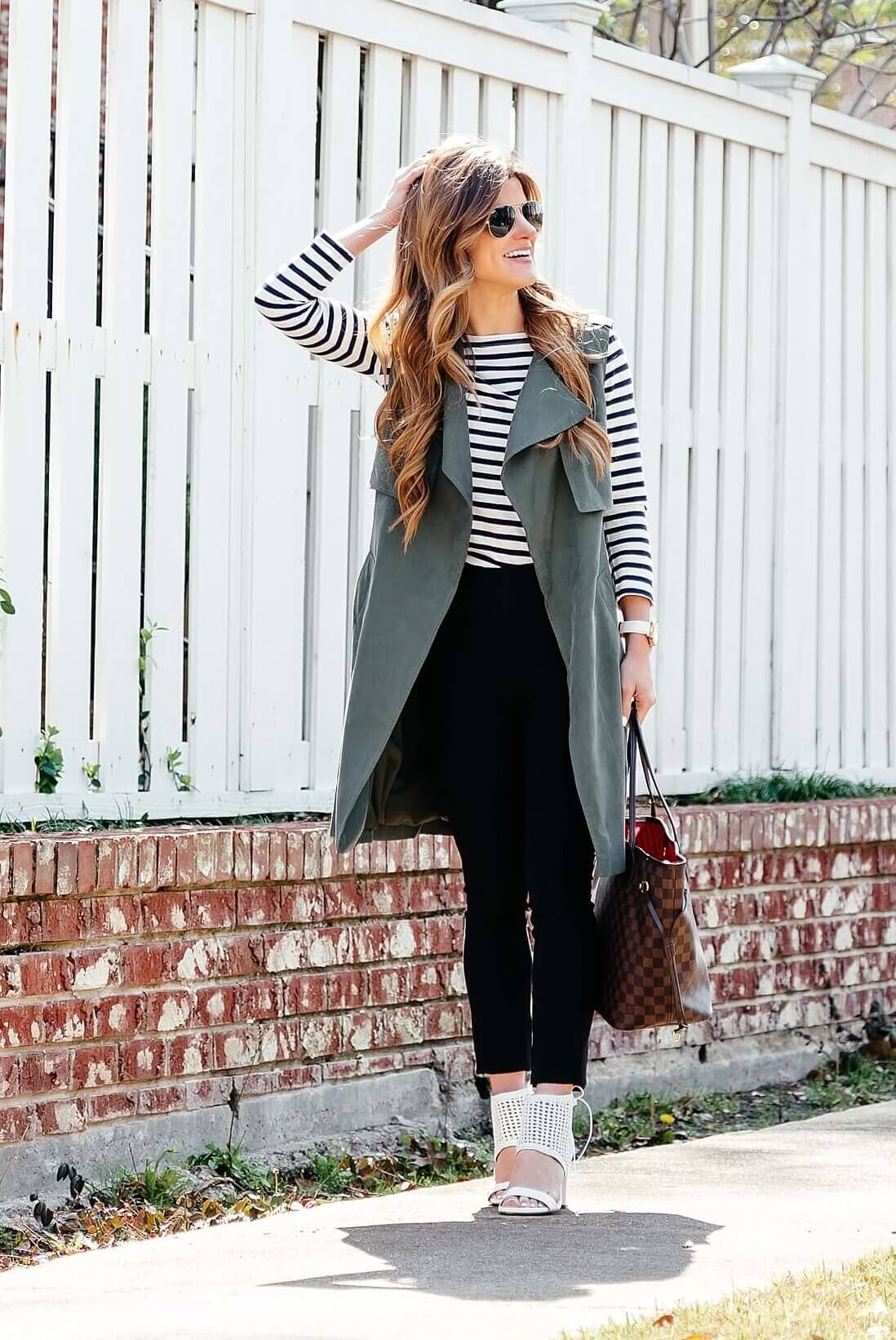 green trench vest, striped tee, black pants, business casual outfit idea