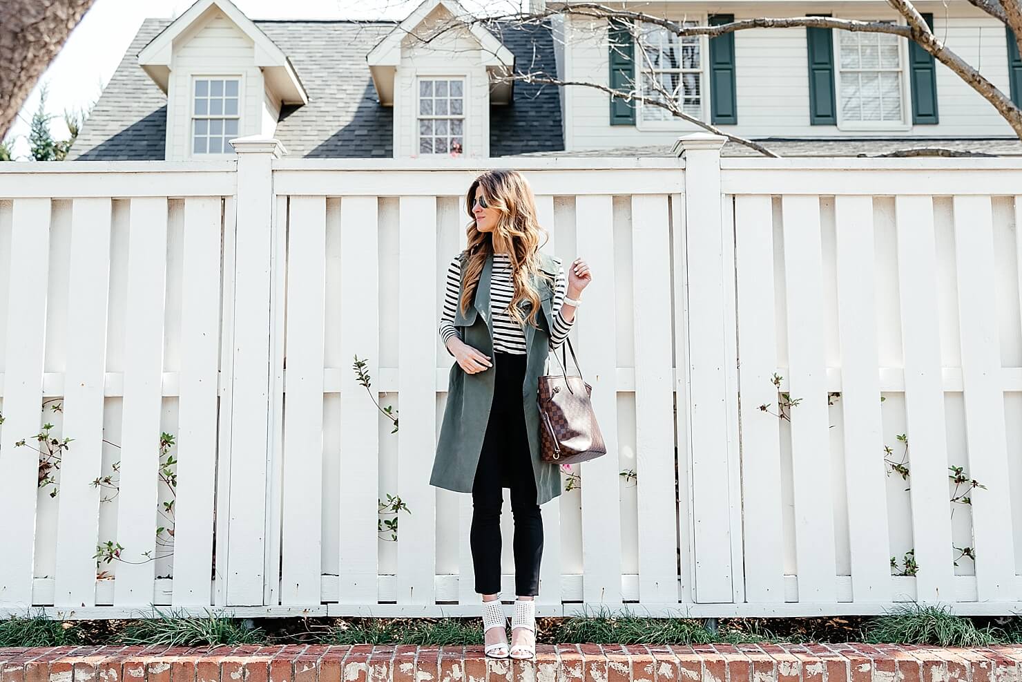 green trench vest, striped tee, black pants