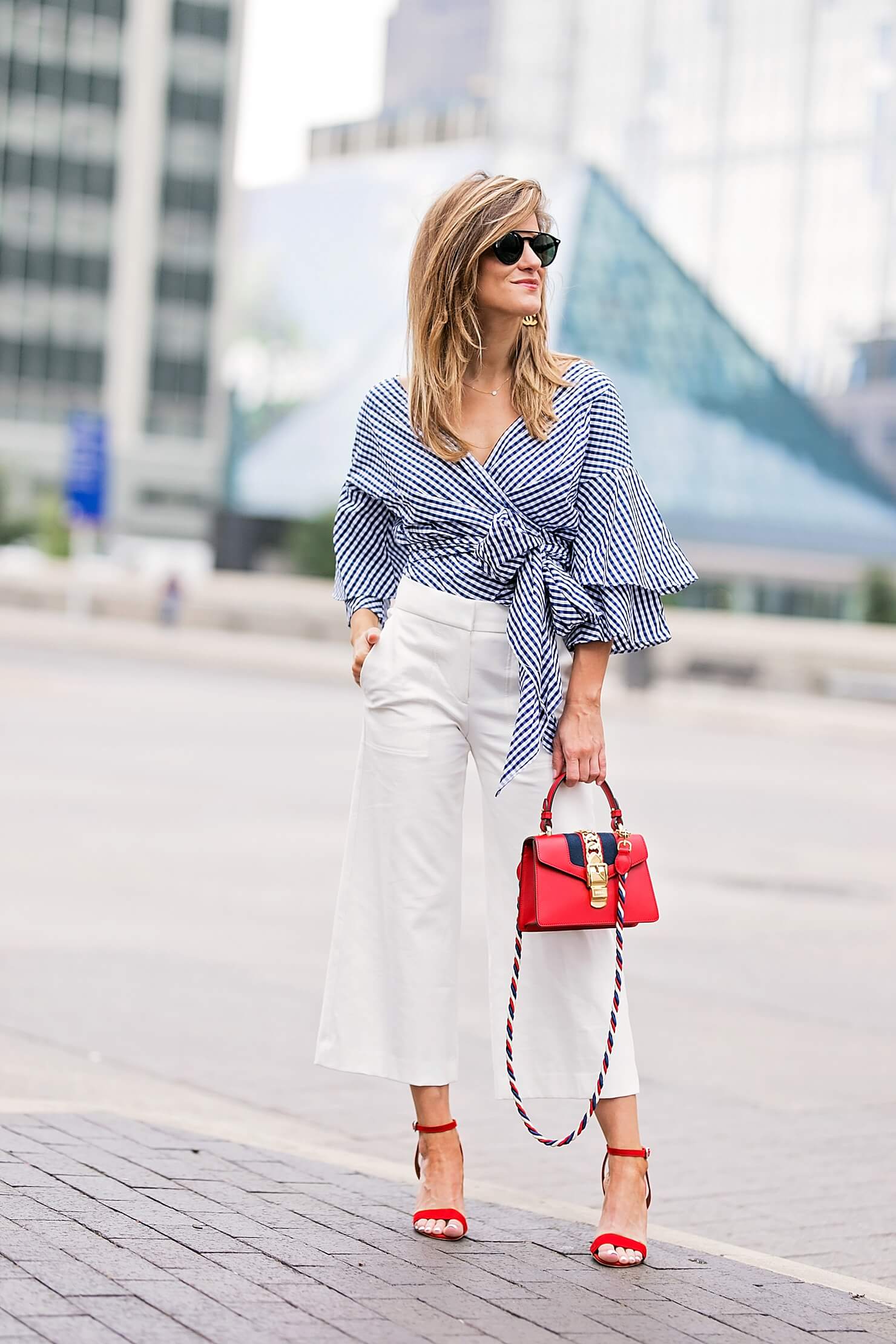 flared white pants with gingham wrap top, red heels and red bag, workwear