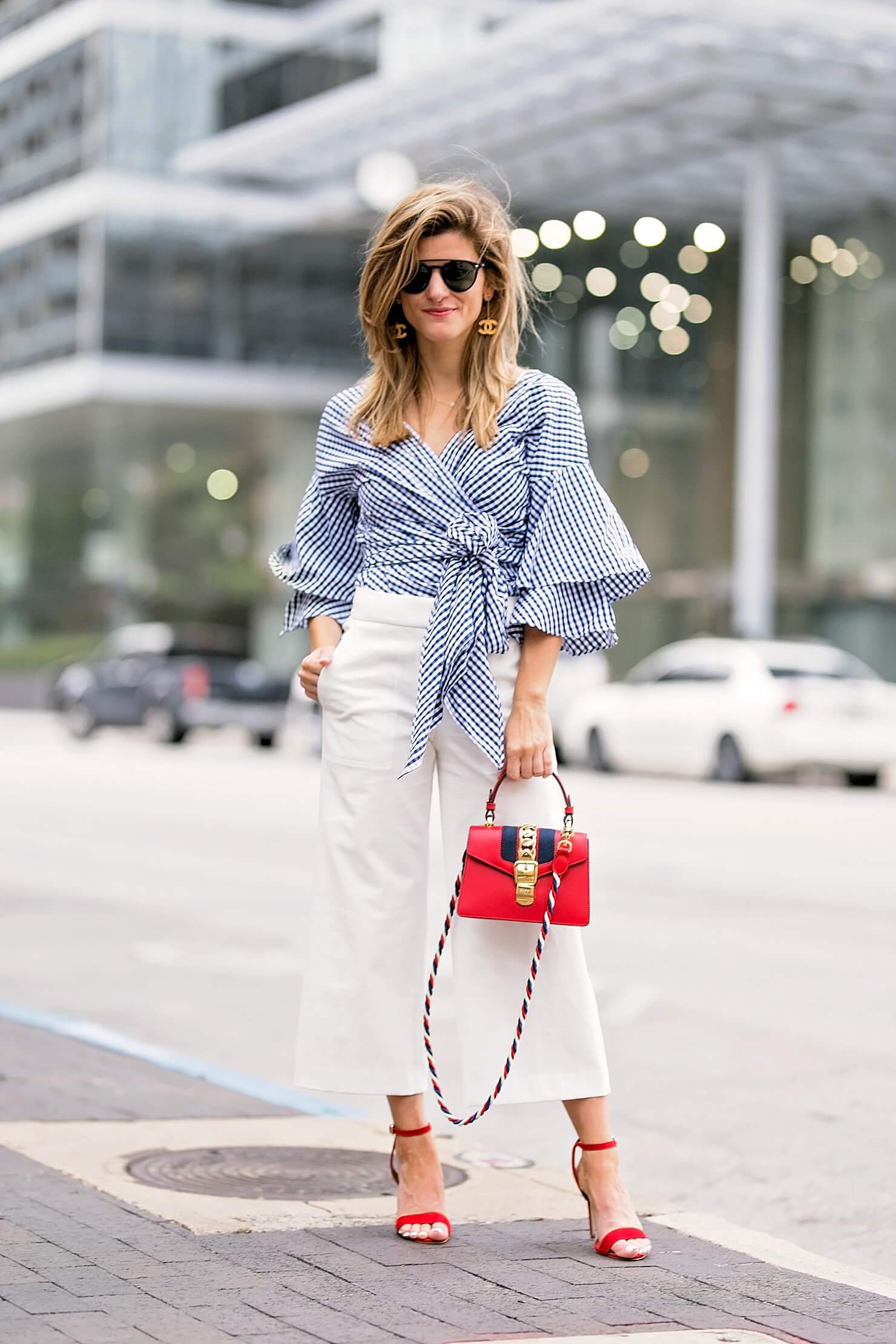 flared white pants with gingham wrap top, red heels and red bag, workwear