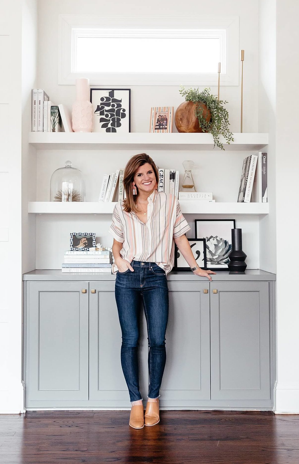 brighton keller standing in front of styled bookshelves sharing tips for styling bookshelves